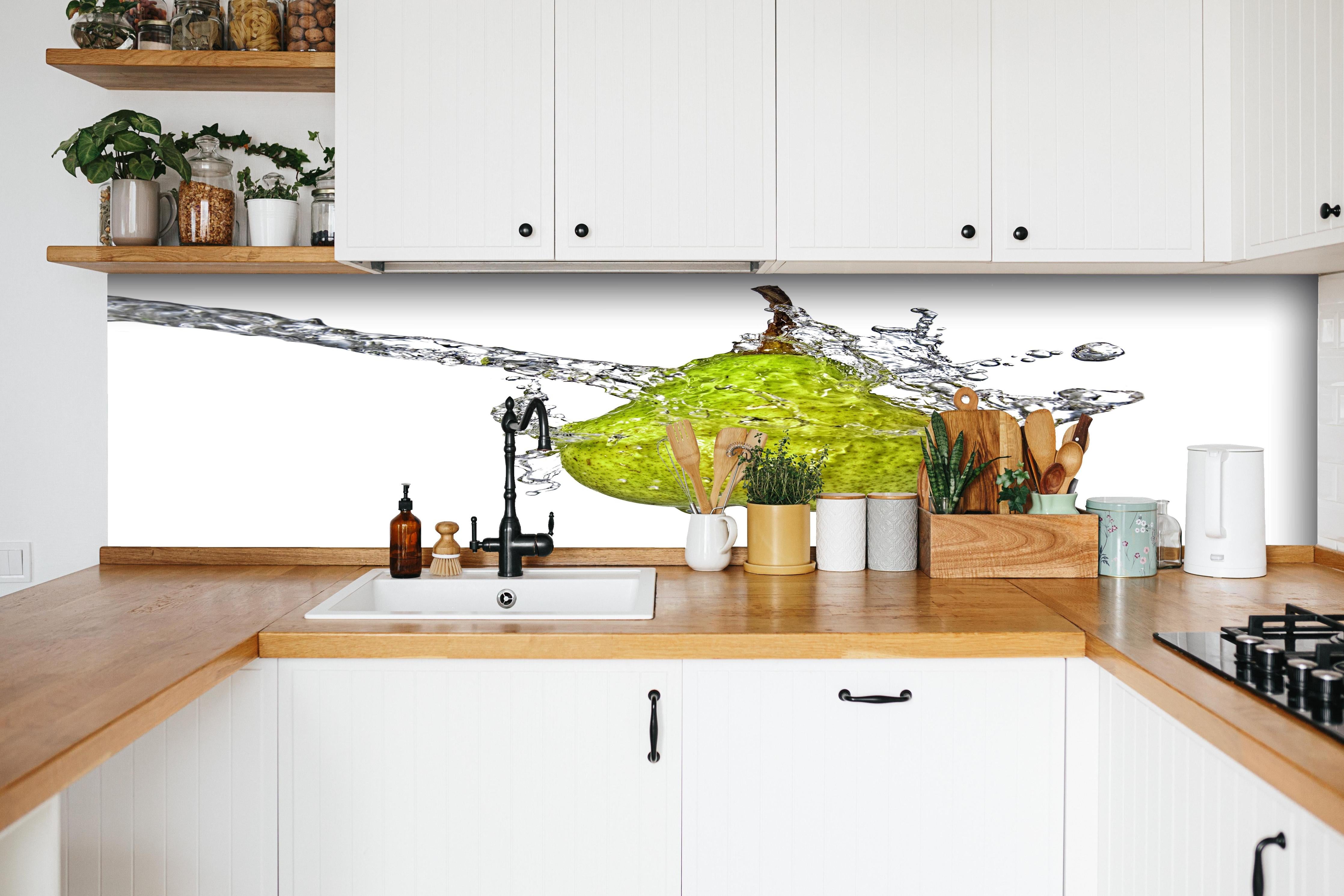 Küche - Spritzige Birne hinter weißen Hochglanz-Küchenregalen und schwarzem Wasserhahn