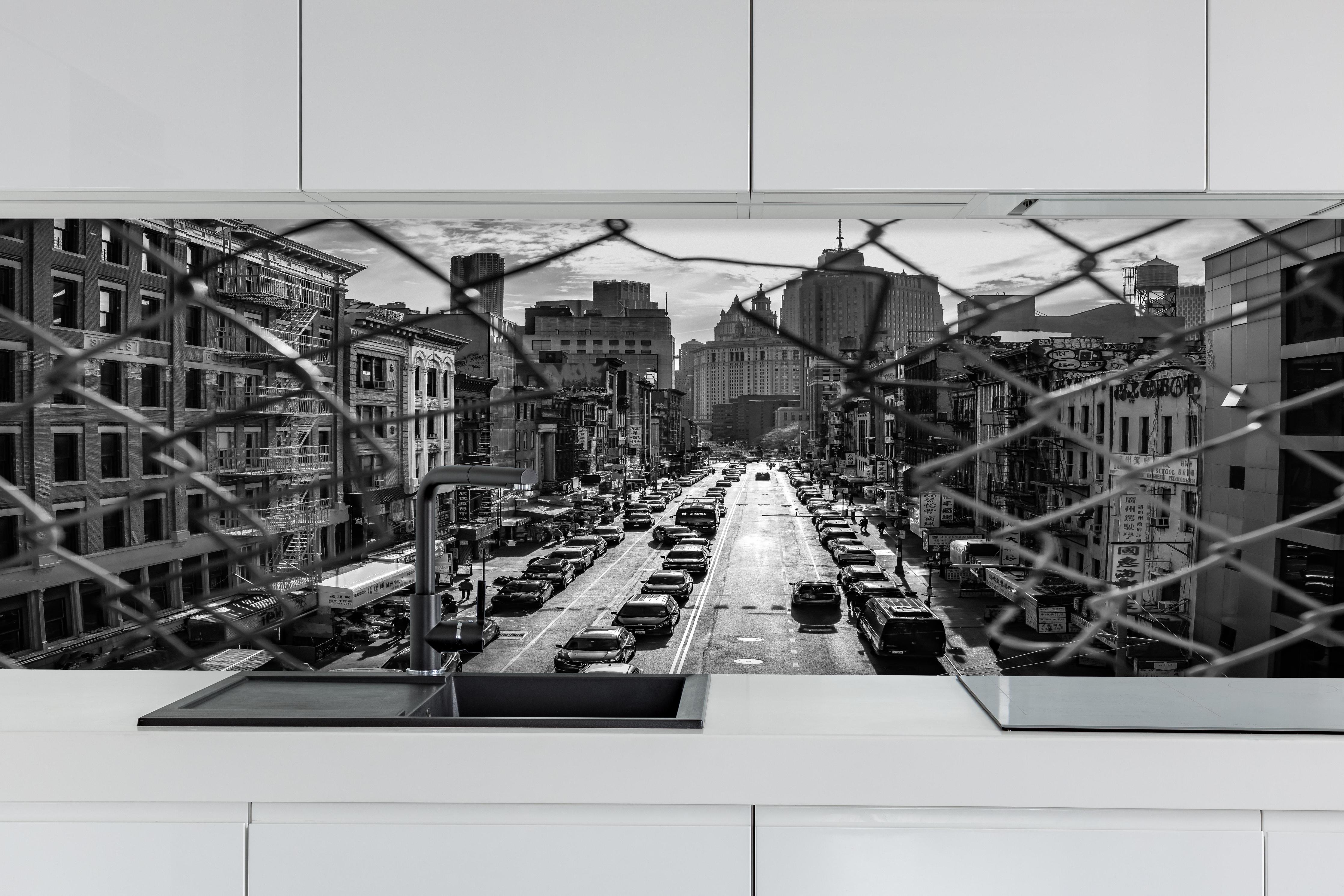 Küche - Stadtbild - China Town, New York hinter weißen Hochglanz-Küchenregalen und schwarzem Wasserhahn