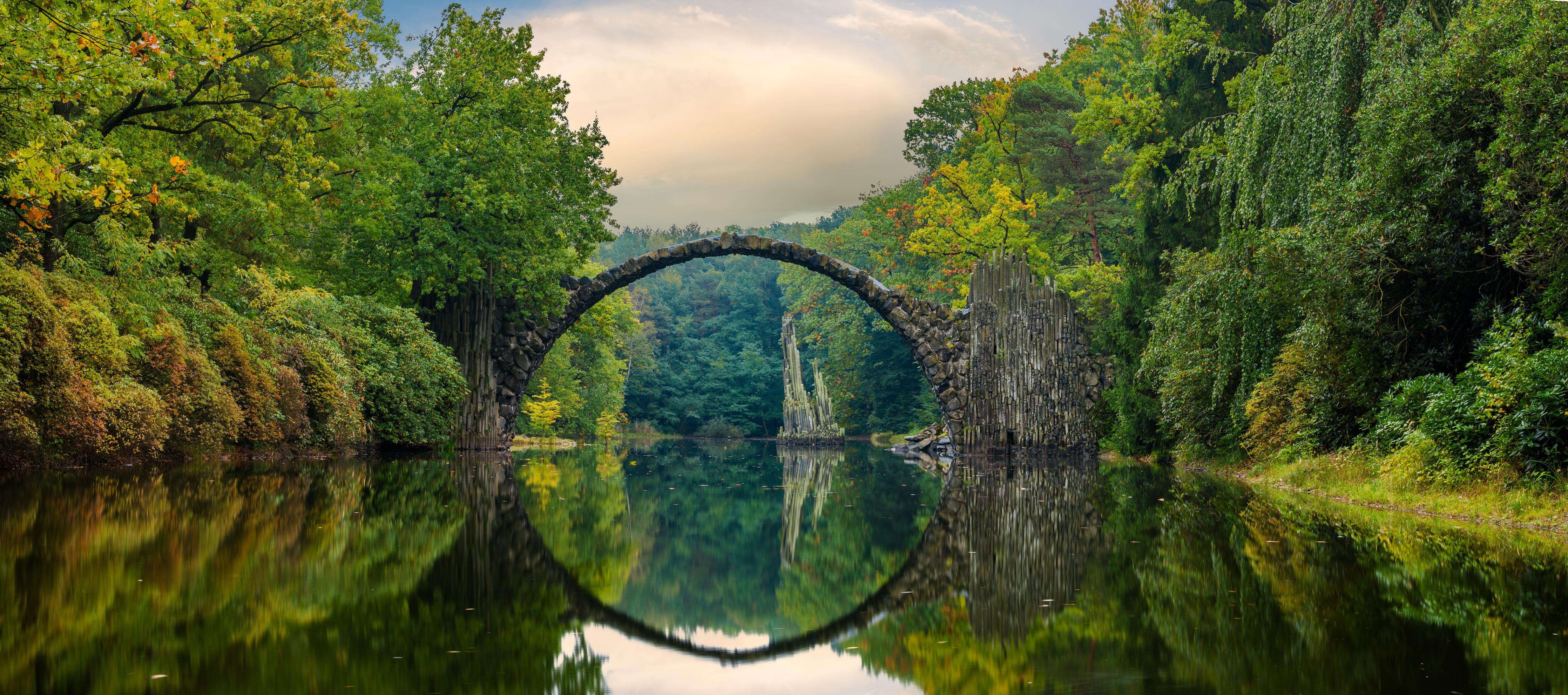 Küchenrückwand-Steinbrücke über Fluss im Wald