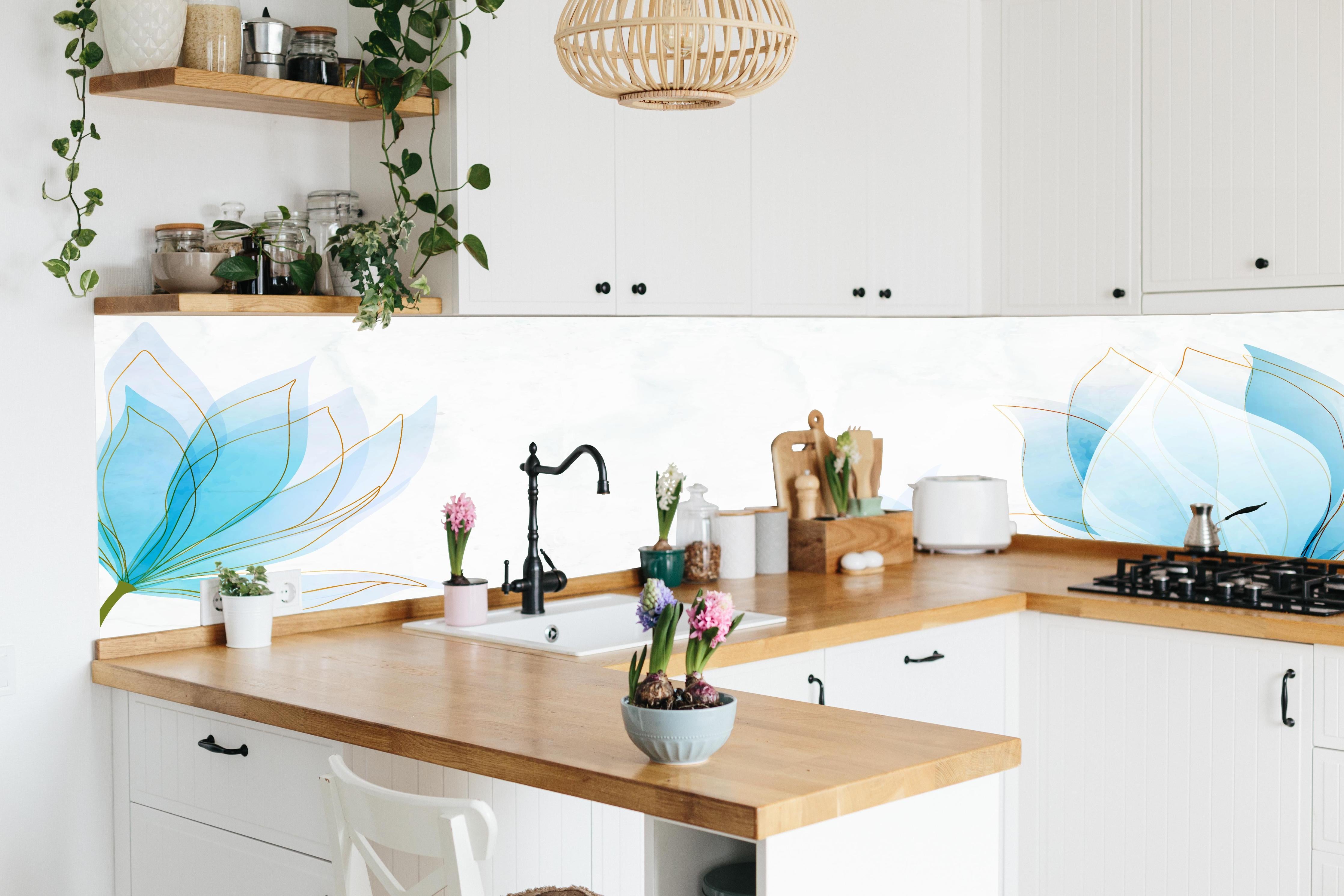 Küche - Stilvolle Blumenzeichnung in Pastellblau hinter weißen Hochglanz-Küchenregalen und schwarzem Wasserhahn
