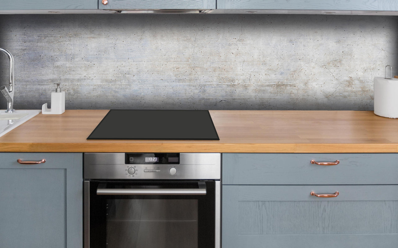 Küche - Stilvolle grau-weiße Betonwand Textur hinter weißen Hochglanz-Küchenregalen und schwarzem Wasserhahn