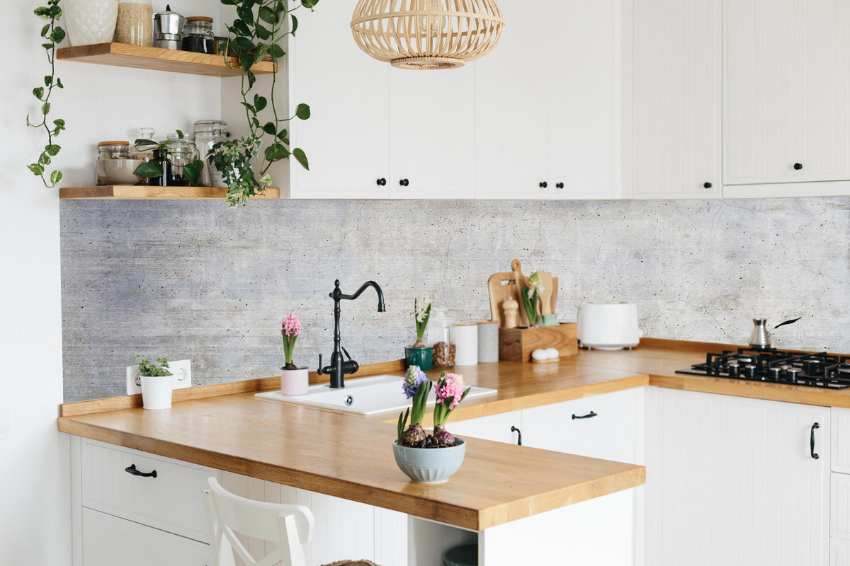 Küche - Stilvolle grau-weiße Betonwand Textur hinter weißen Hochglanz-Küchenregalen und schwarzem Wasserhahn