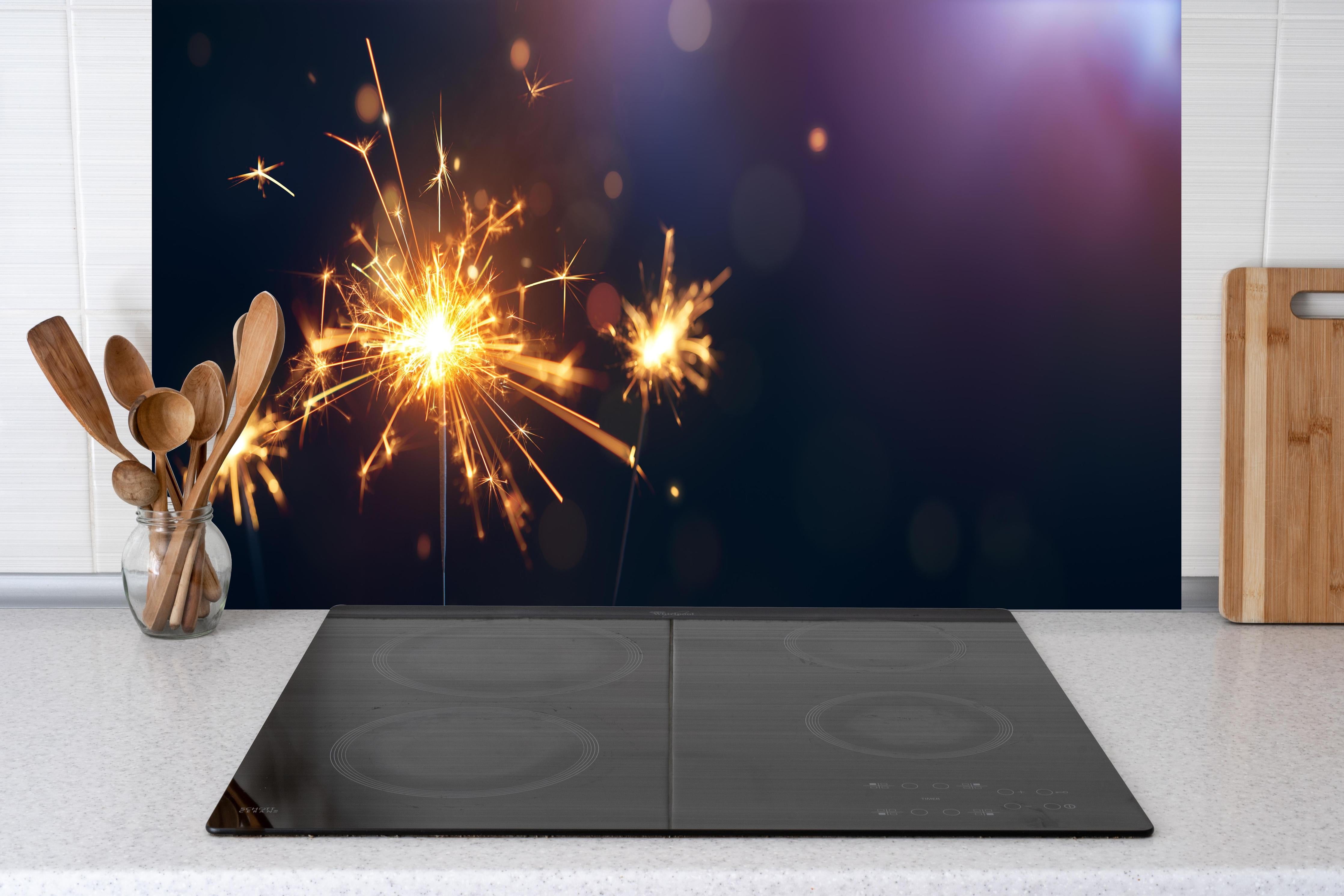 Küche - Strahlendes Wunderkerzen-Goldlichtfeuerwerk hinter weißen Hochglanz-Küchenregalen und schwarzem Wasserhahn