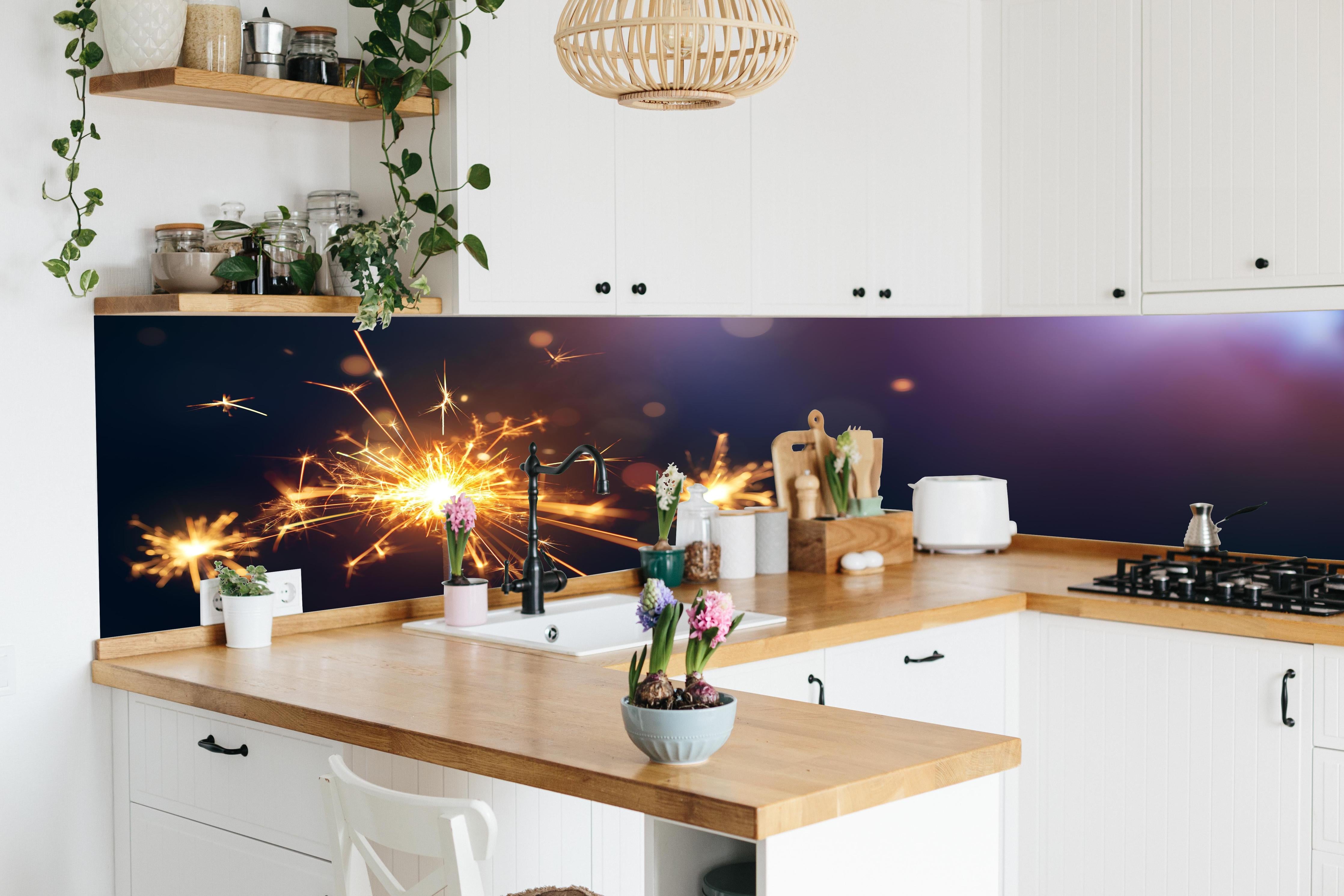 Küche - Strahlendes Wunderkerzen-Goldlichtfeuerwerk hinter weißen Hochglanz-Küchenregalen und schwarzem Wasserhahn