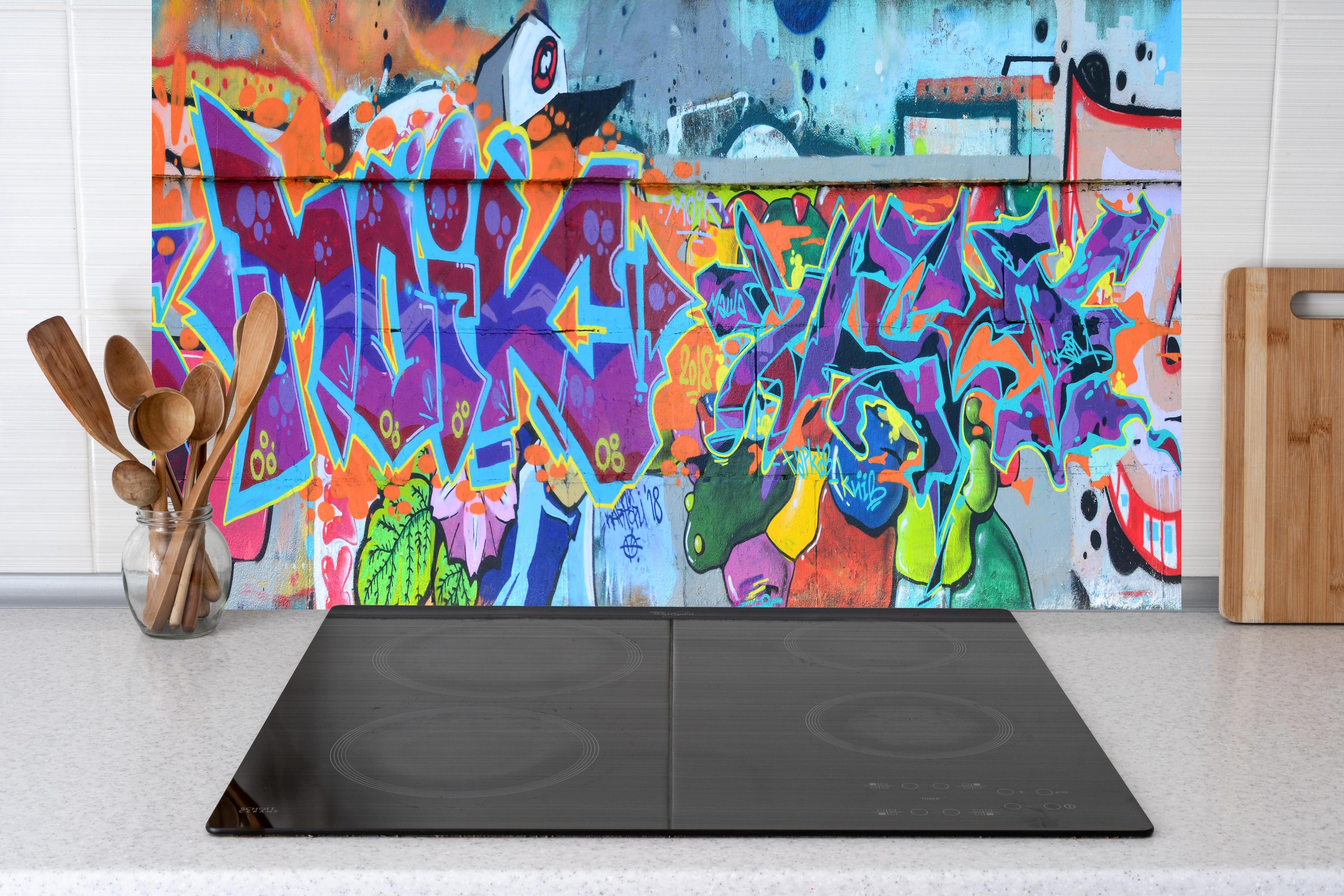 Küche - Street Art Graffiti in Lila-Tönen hinter weißen Hochglanz-Küchenregalen und schwarzem Wasserhahn