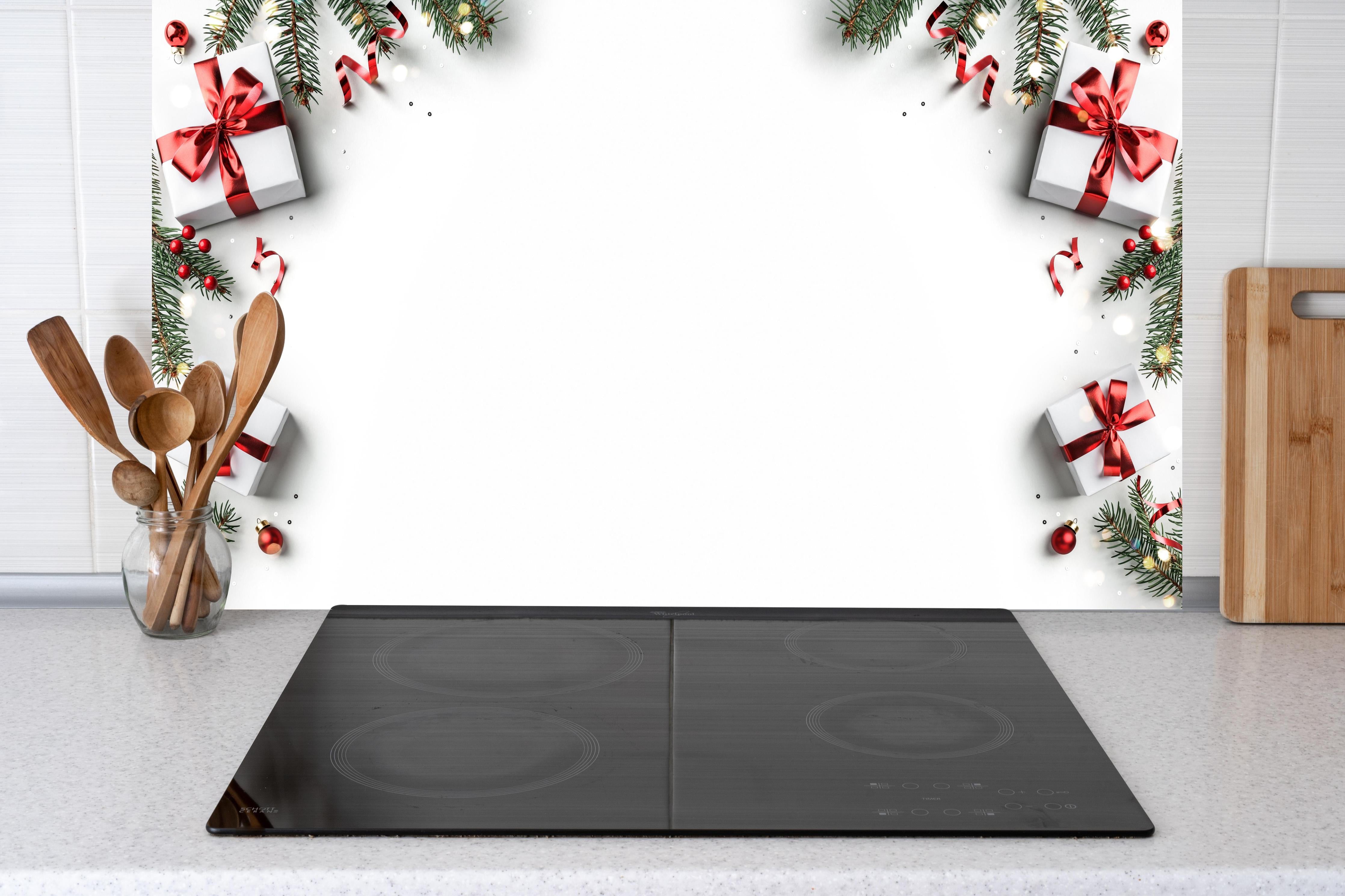 Küche - Tannenzweige als Rahmen hinter weißen Hochglanz-Küchenregalen und schwarzem Wasserhahn