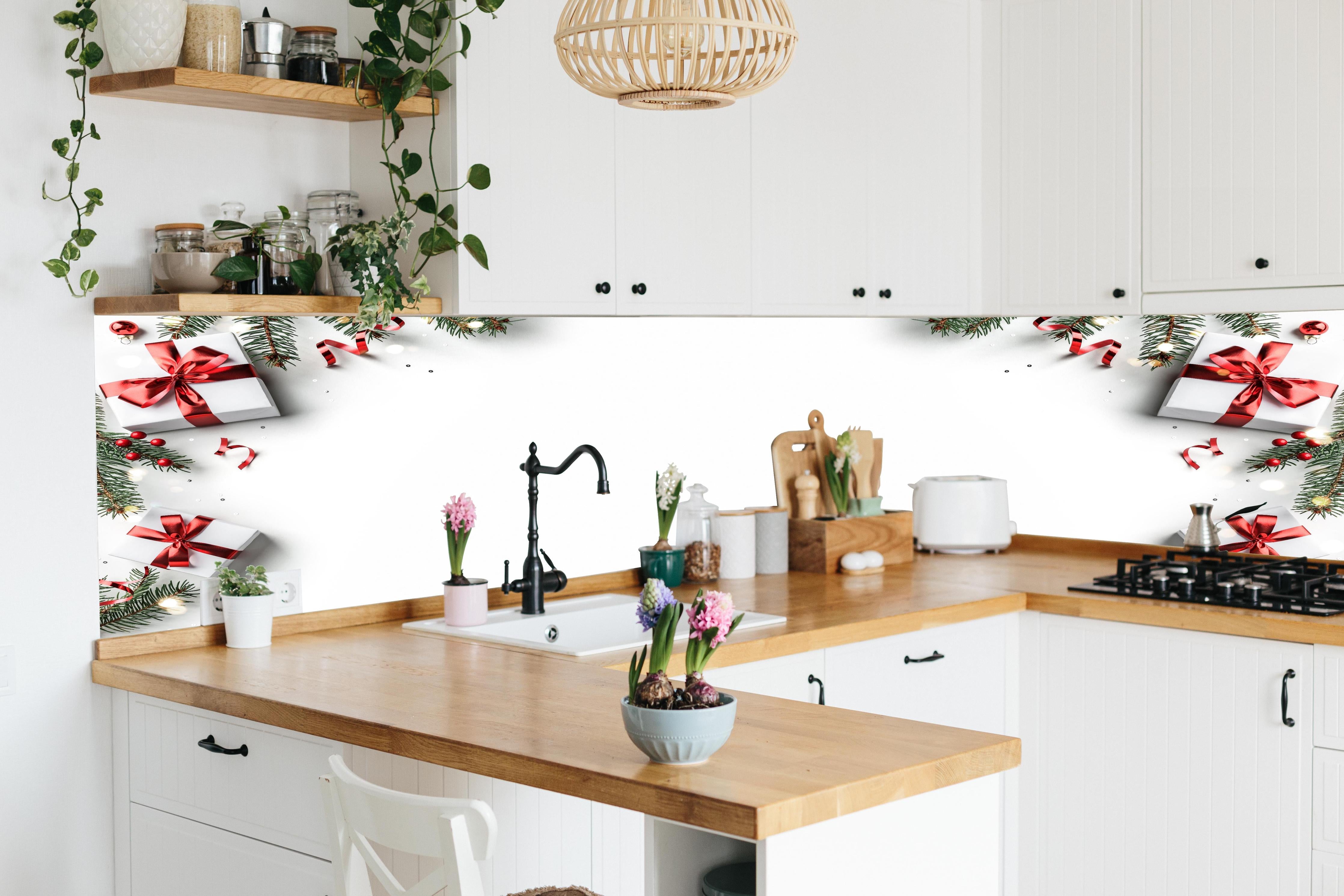 Küche - Tannenzweige als Rahmen hinter weißen Hochglanz-Küchenregalen und schwarzem Wasserhahn