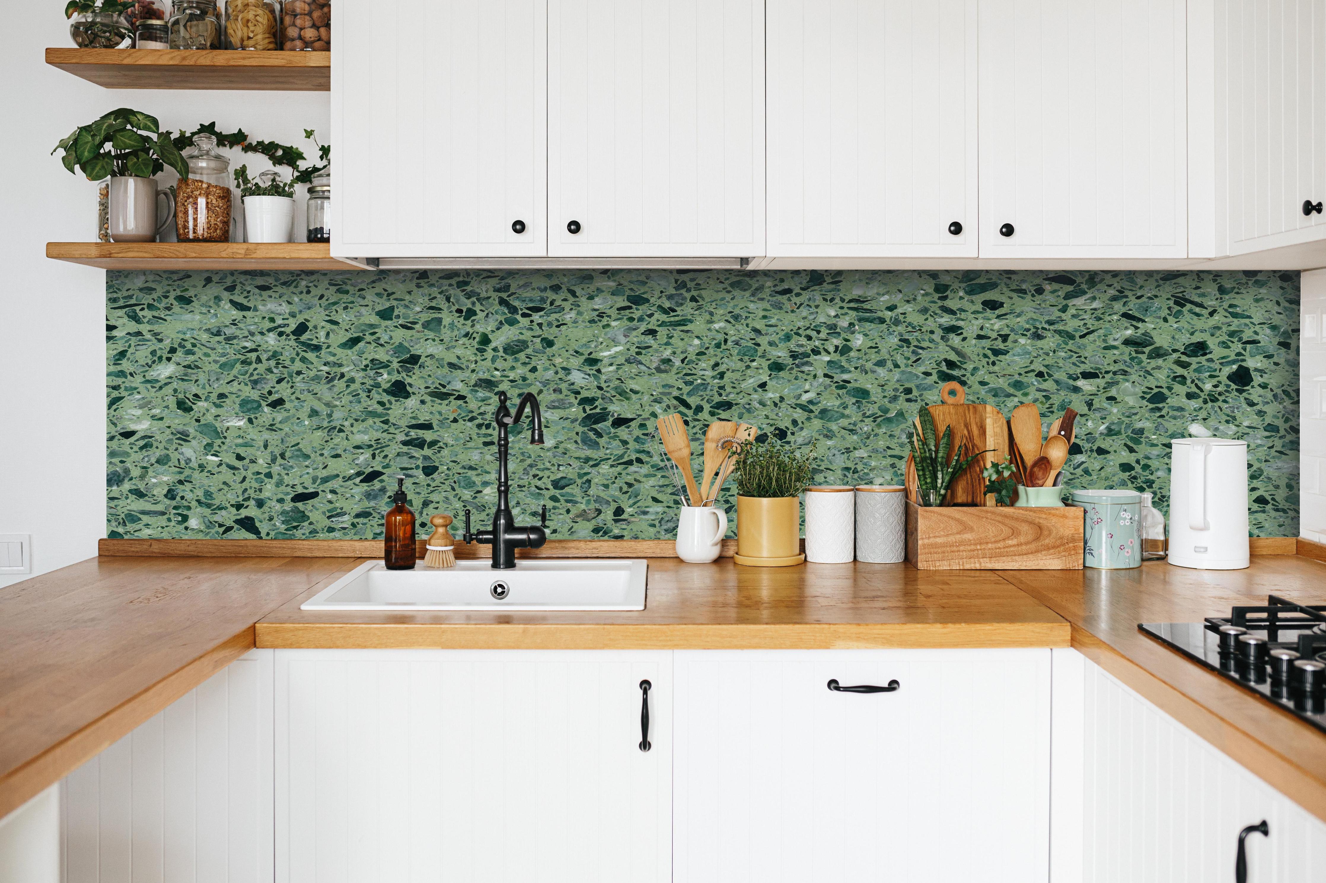 Küche - Terrazzo Textur auf türkisem Hintergrund hinter weißen Hochglanz-Küchenregalen und schwarzem Wasserhahn