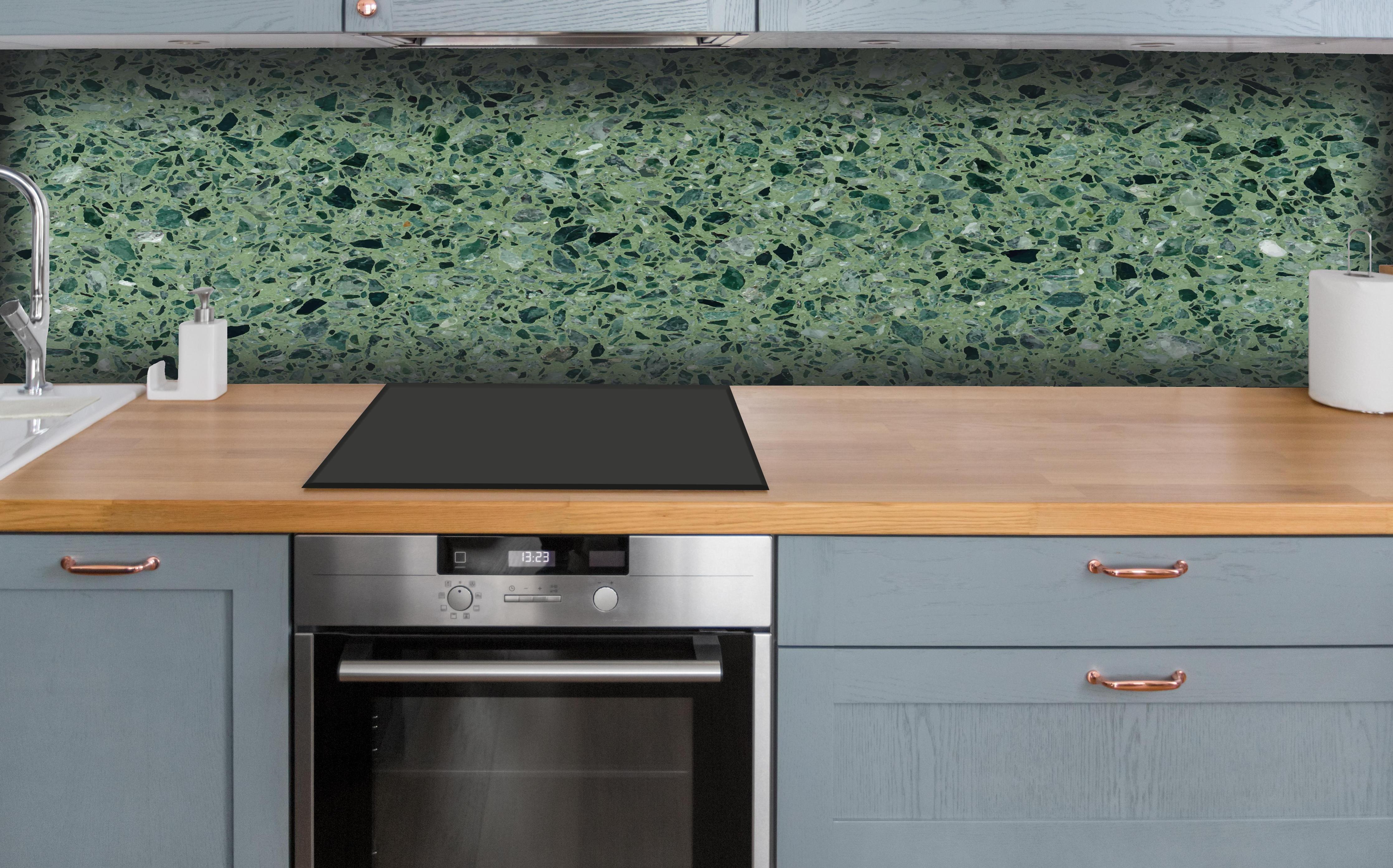 Küche - Terrazzo Textur auf türkisem Hintergrund hinter weißen Hochglanz-Küchenregalen und schwarzem Wasserhahn