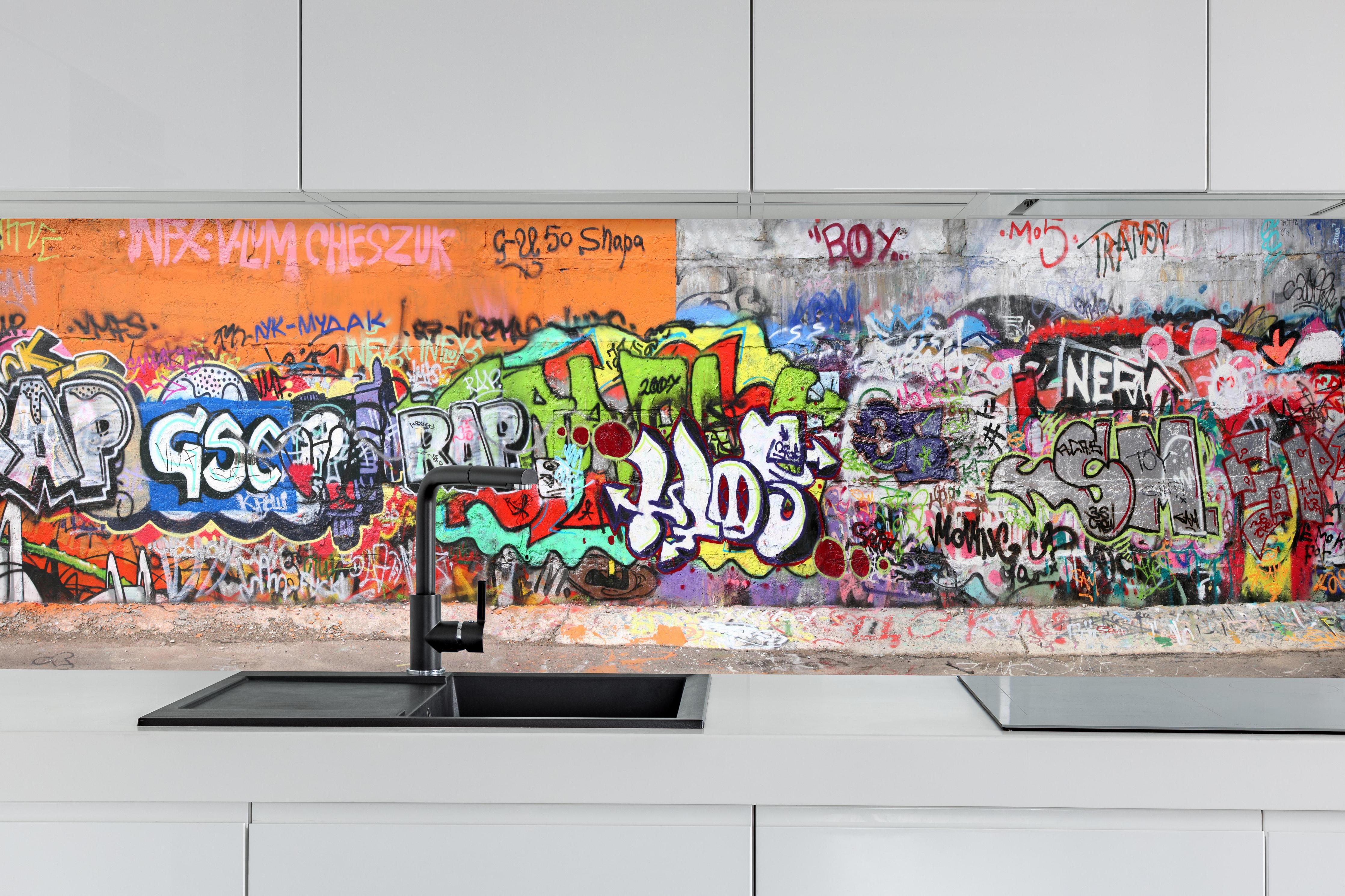 Küche - Textur Urbaner Graffiti-Art Streetstyle hinter weißen Hochglanz-Küchenregalen und schwarzem Wasserhahn