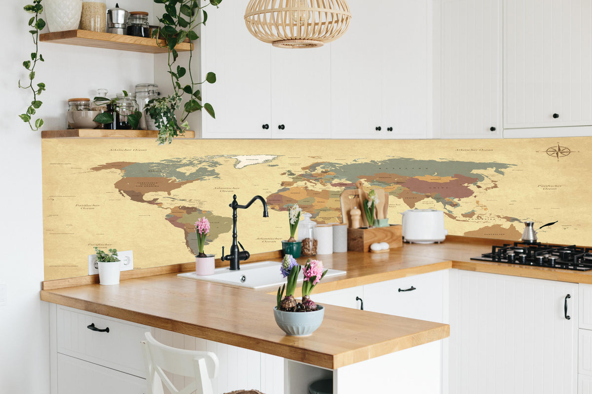 Küche - Texturierte Vintage Weltkarte in Beigetönen hinter weißen Hochglanz-Küchenregalen und schwarzem Wasserhahn