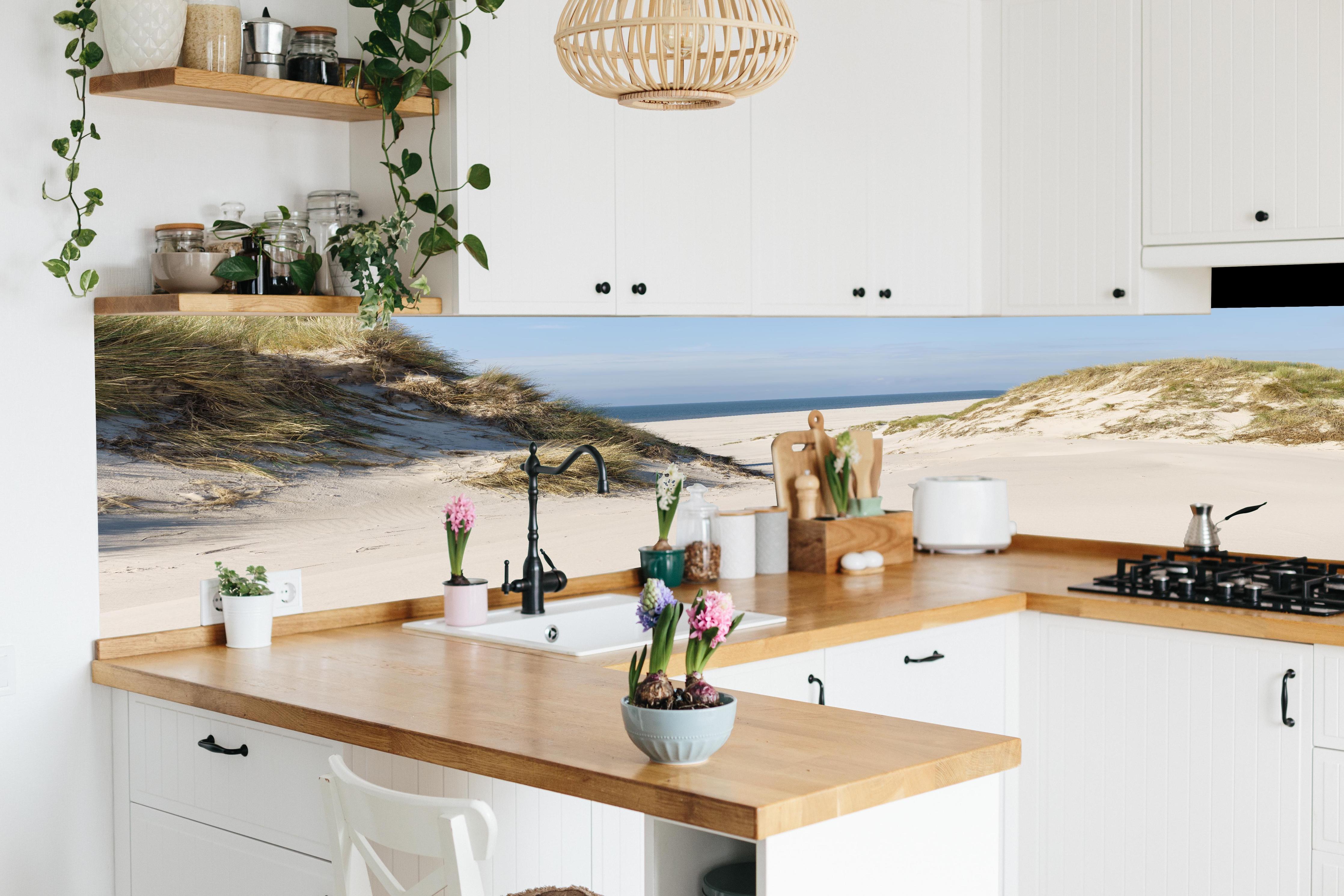 Küche - Traumhafte Sanddüne mit Blick auf das ruhige blaue Meer hinter weißen Hochglanz-Küchenregalen und schwarzem Wasserhahn