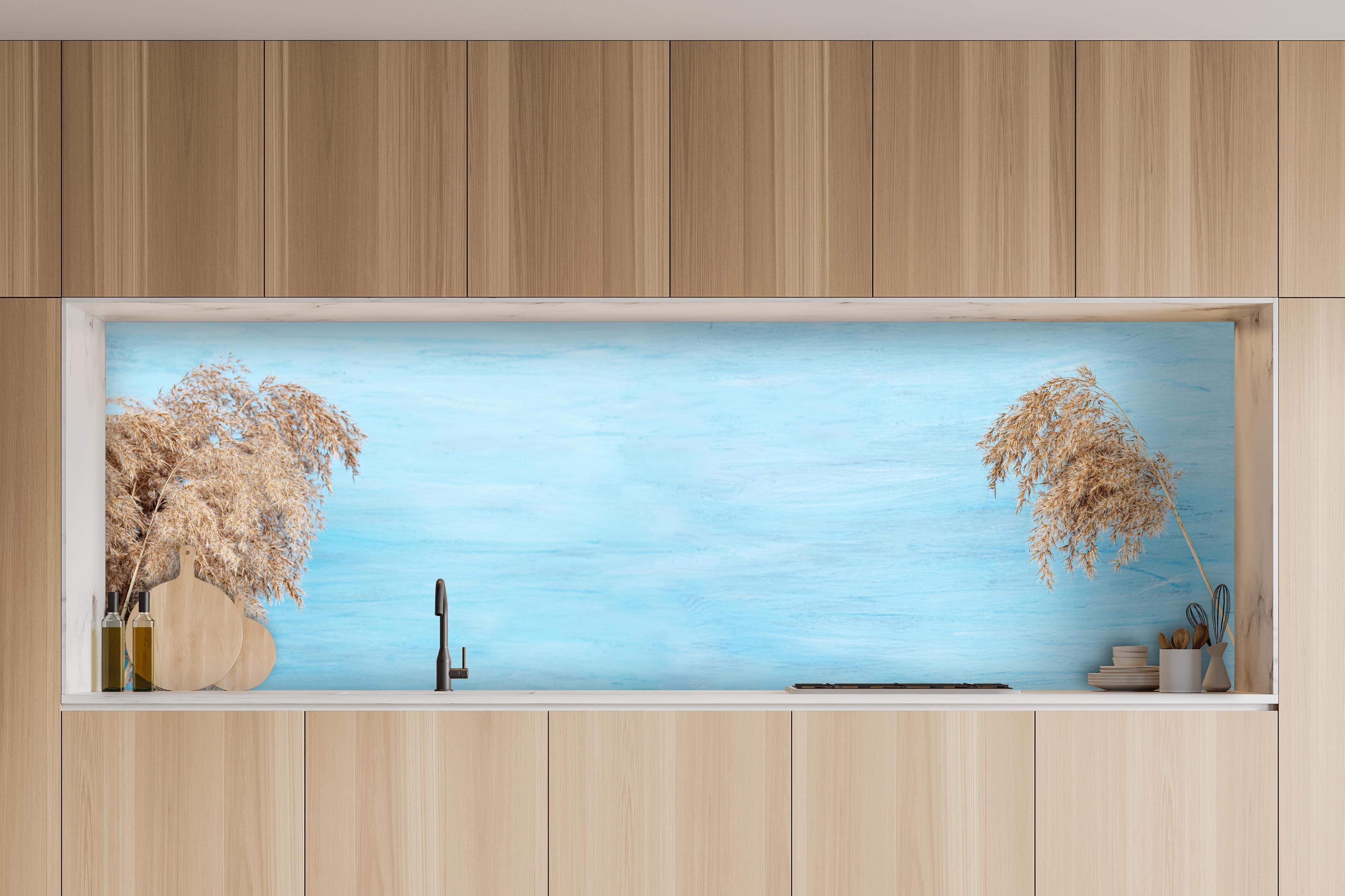 Küche - Trockene Pflanzen über dem Meer hinter weißen Hochglanz-Küchenregalen und schwarzem Wasserhahn