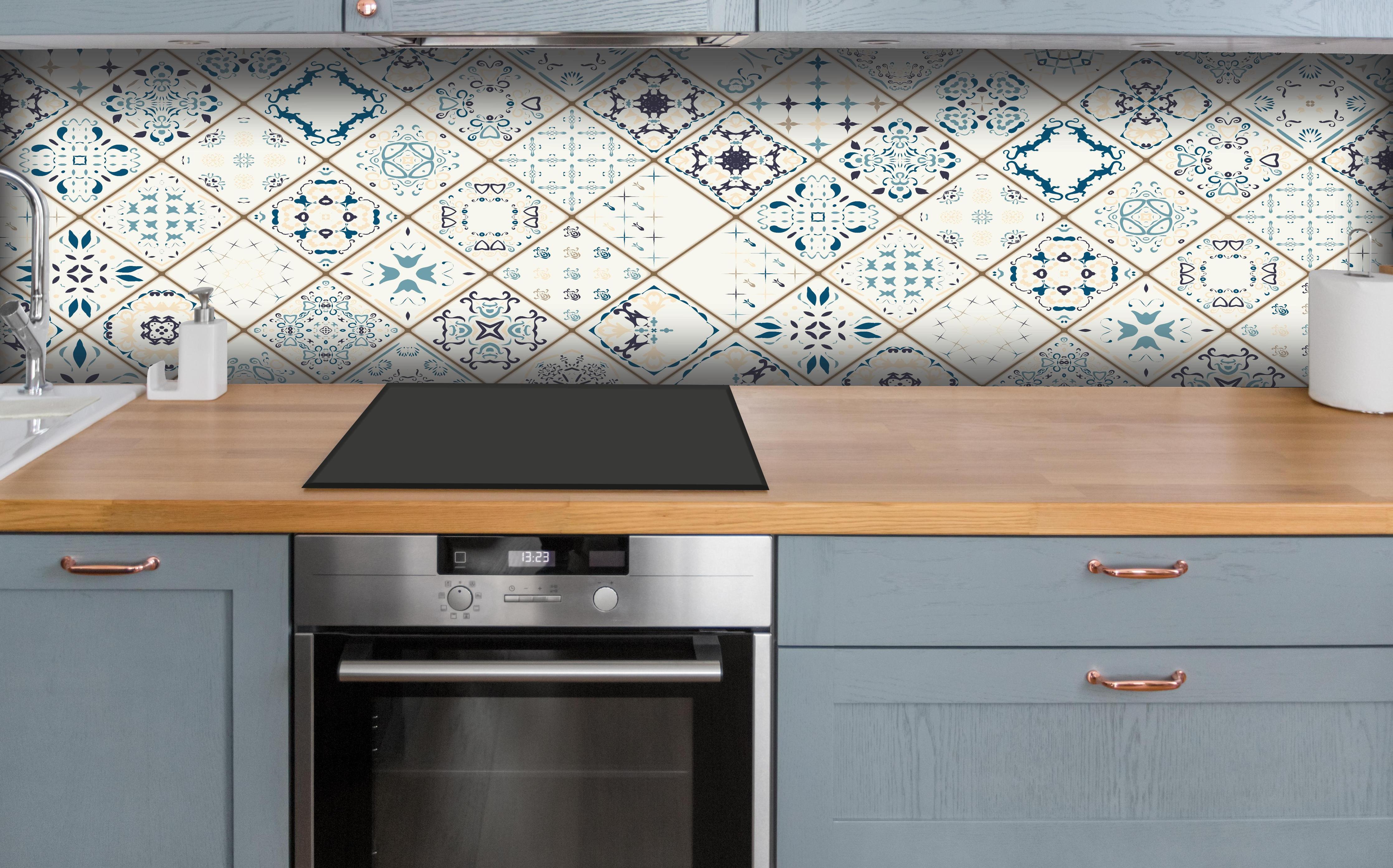 Küche - Vintage Fliesenmuster in Blau und Beige hinter weißen Hochglanz-Küchenregalen und schwarzem Wasserhahn