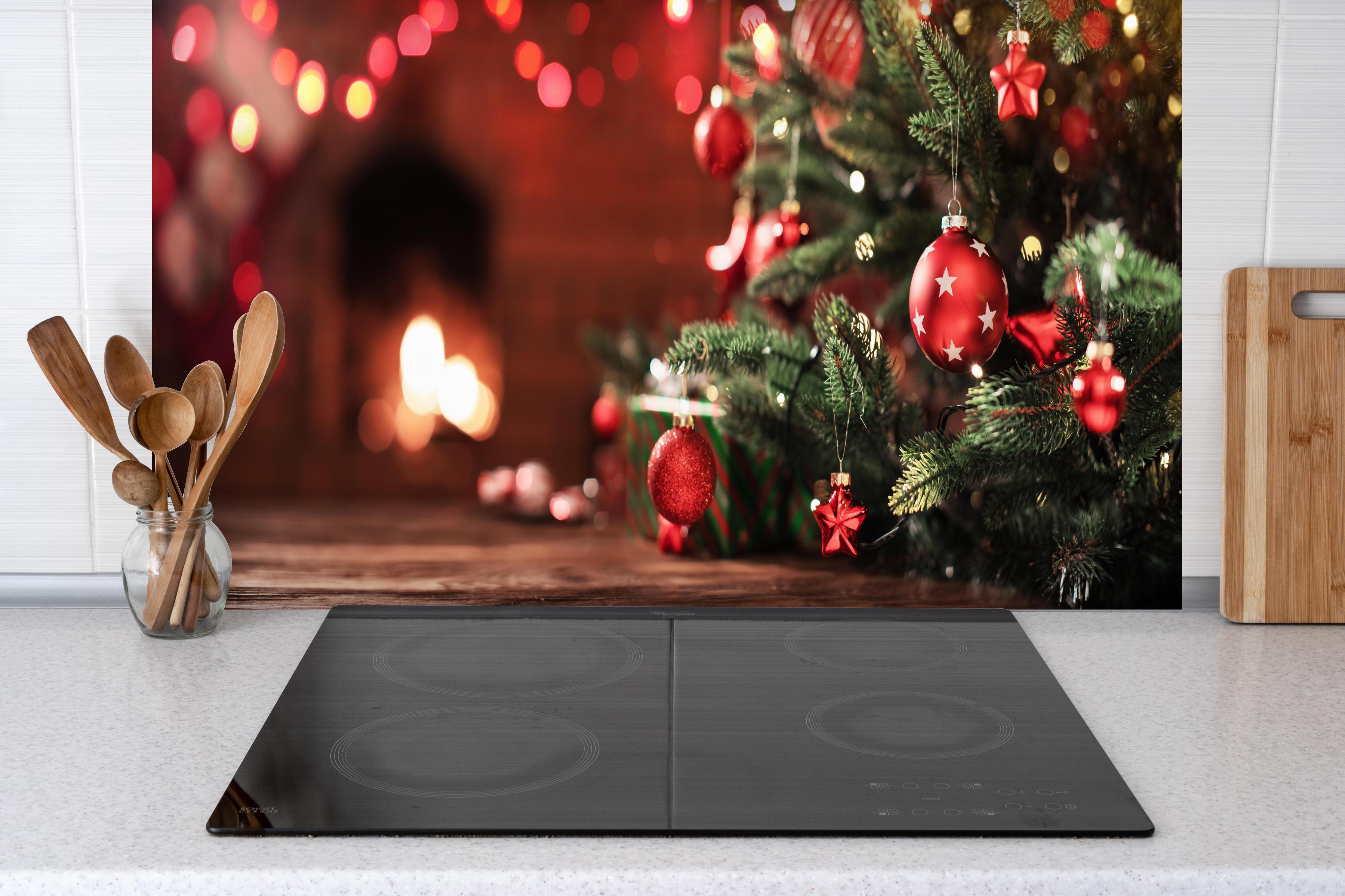 Küche - Weihnachtsbaum mit Dekorationen hinter weißen Hochglanz-Küchenregalen und schwarzem Wasserhahn