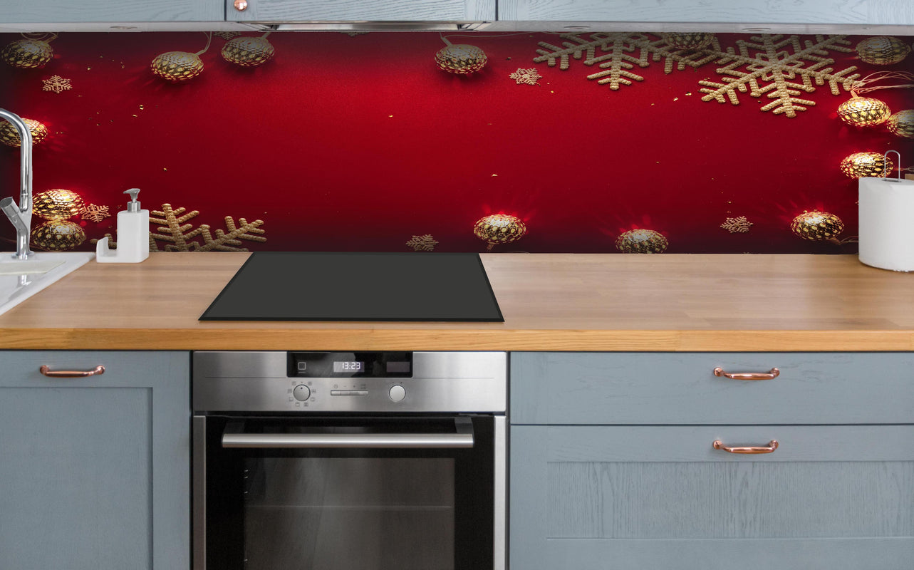 Küche - Weihnachtsdekoration auf rotem Hintergrund hinter weißen Hochglanz-Küchenregalen und schwarzem Wasserhahn