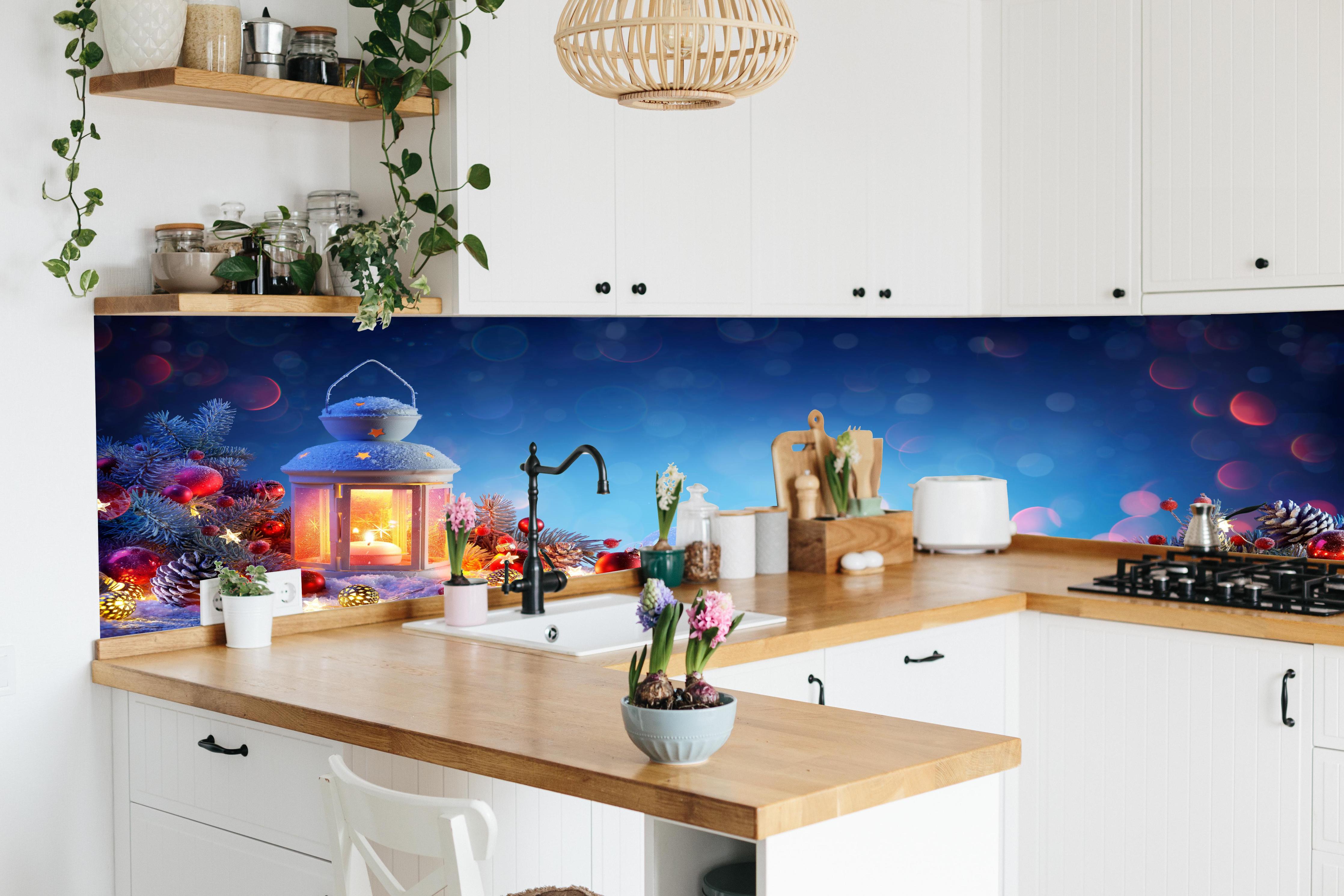 Küche - Weihnachtslaterne auf verschneiten Tisch hinter weißen Hochglanz-Küchenregalen und schwarzem Wasserhahn