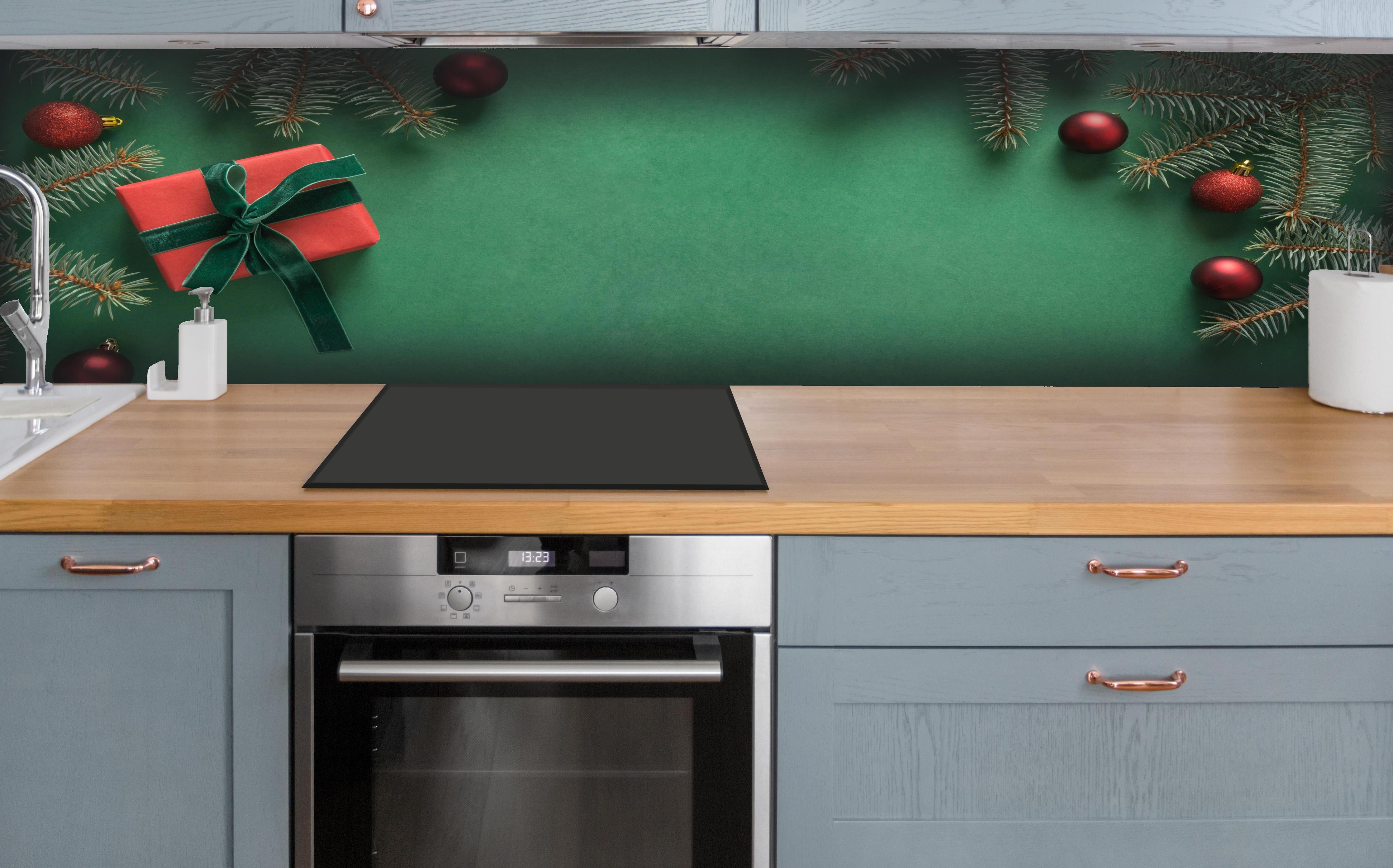 Küche - Weihnachtsrahmen auf grünem Hintergrund hinter weißen Hochglanz-Küchenregalen und schwarzem Wasserhahn