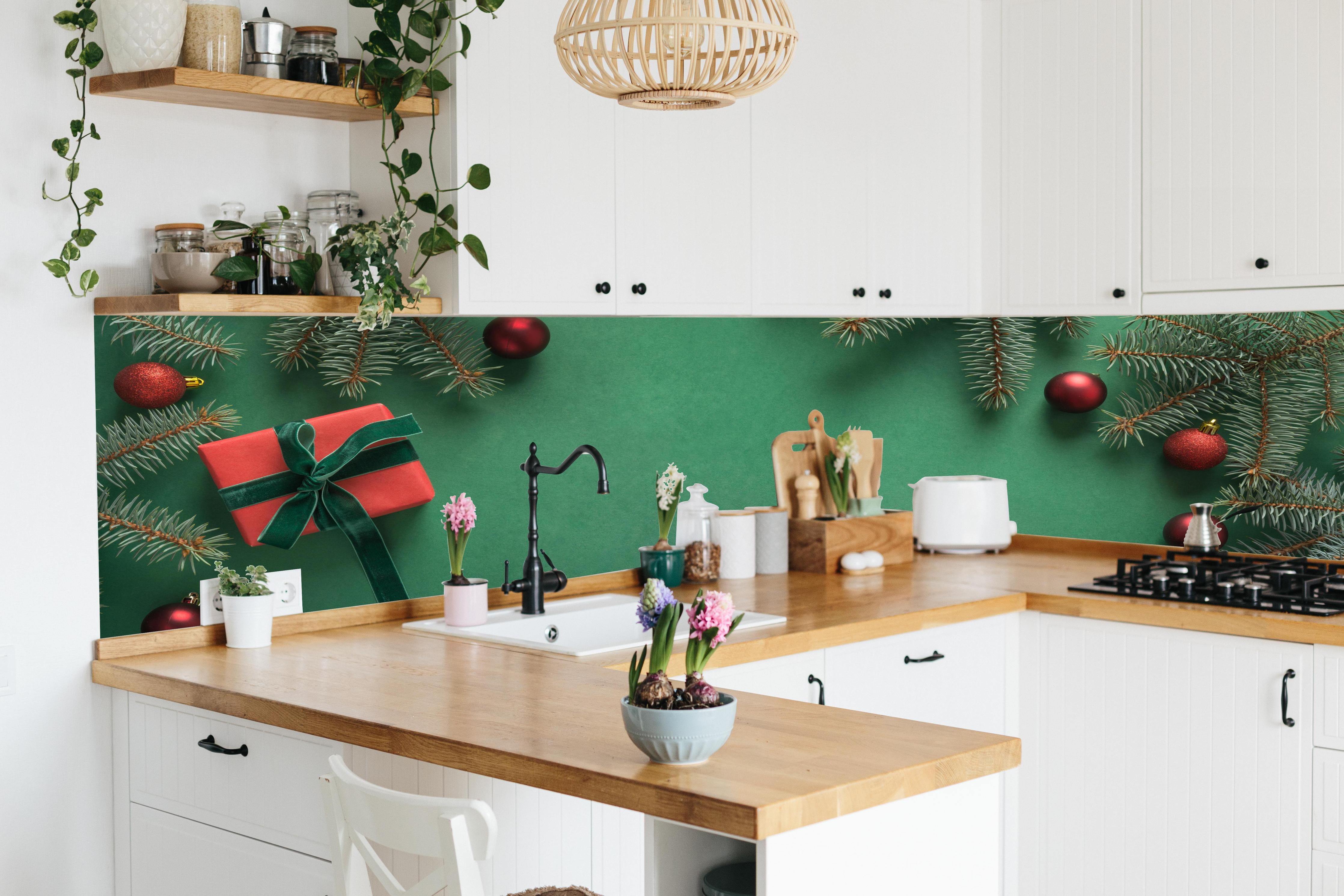 Küche - Weihnachtsrahmen auf grünem Hintergrund hinter weißen Hochglanz-Küchenregalen und schwarzem Wasserhahn