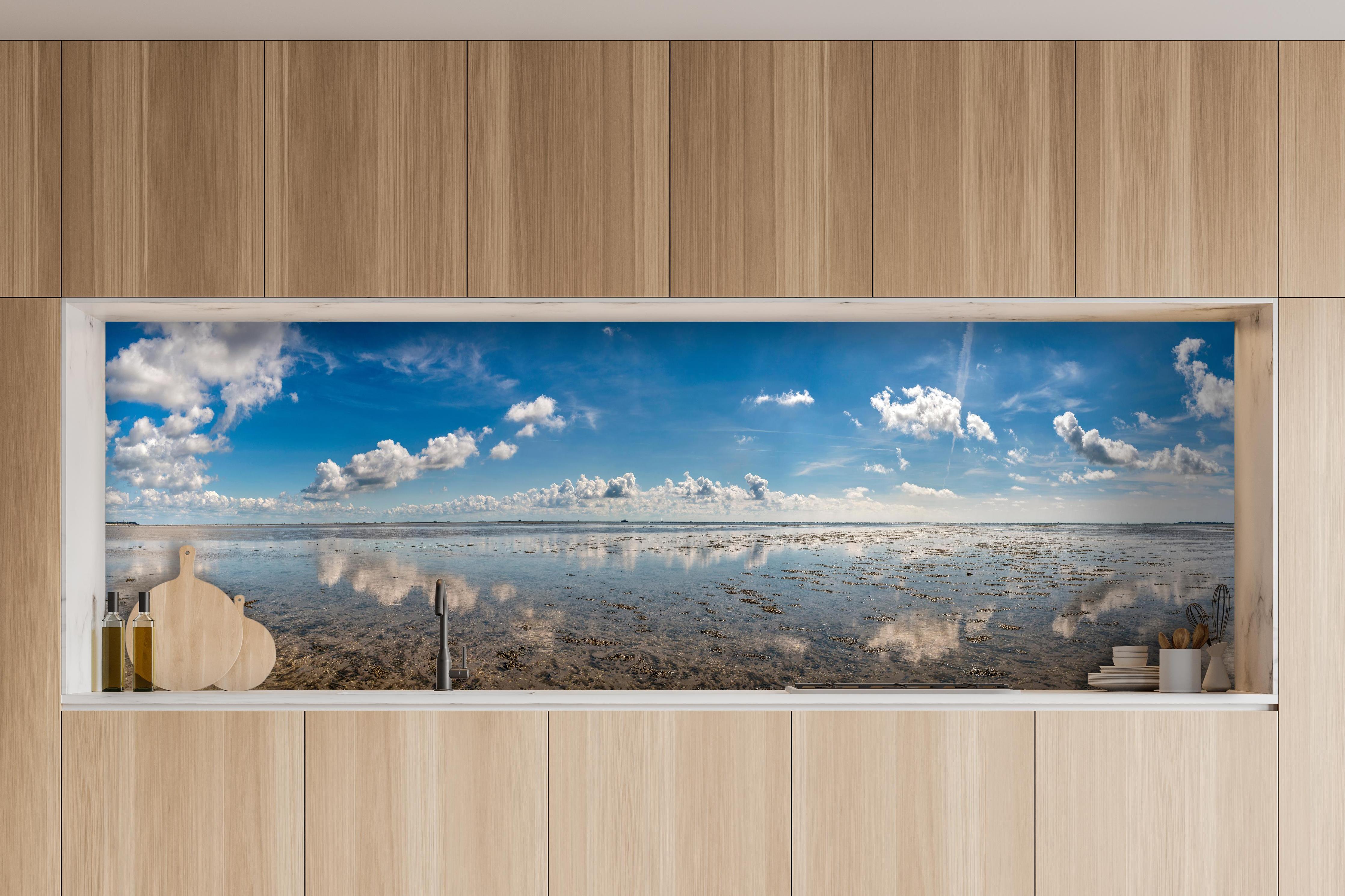 Küche - Weitläufiger Himmel und spiegelnde Wasseroberfläche mit Wolkenreflexionen hinter weißen Hochglanz-Küchenregalen und schwarzem Wasserhahn