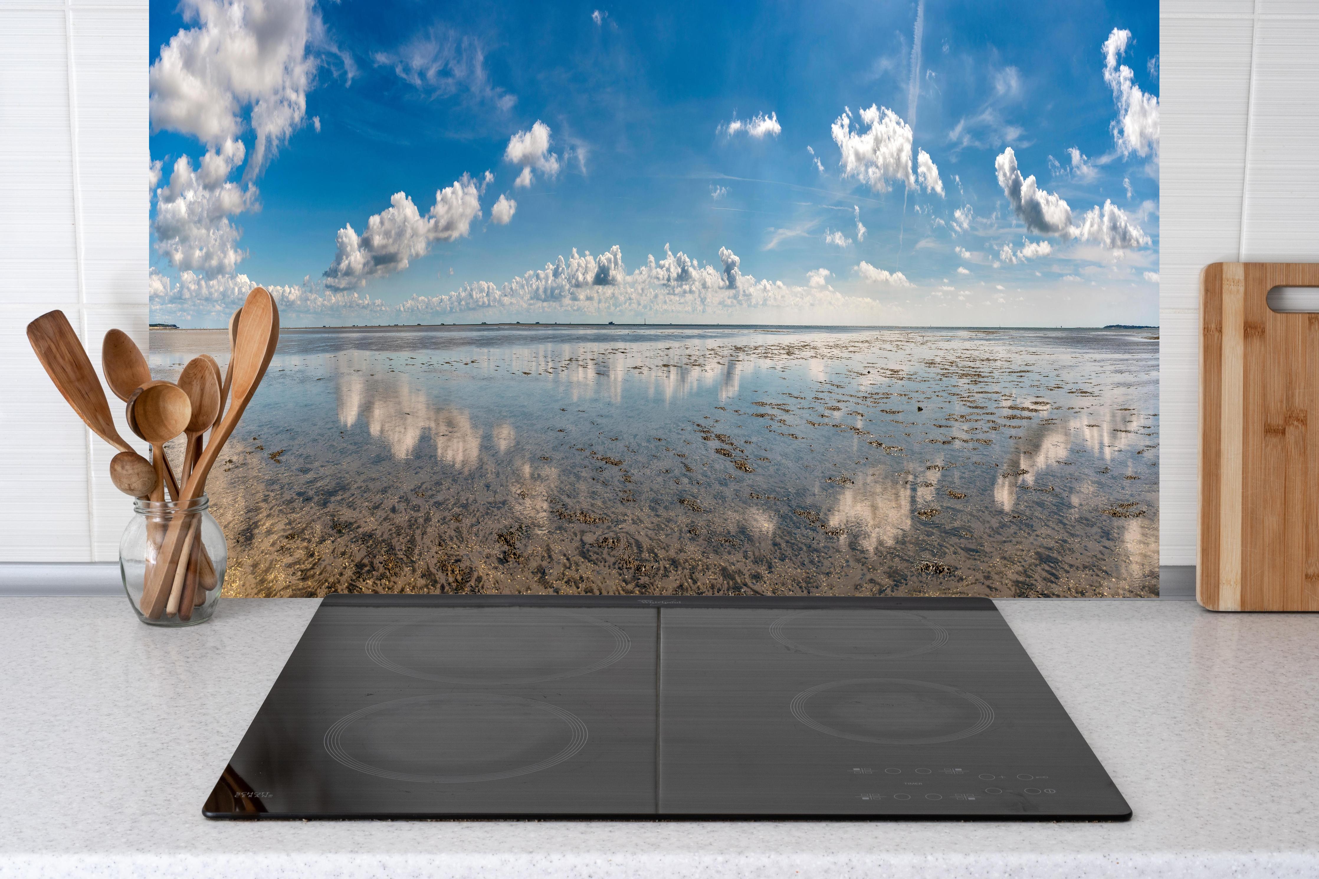 Küche - Weitläufiger Himmel und spiegelnde Wasseroberfläche mit Wolkenreflexionen hinter weißen Hochglanz-Küchenregalen und schwarzem Wasserhahn