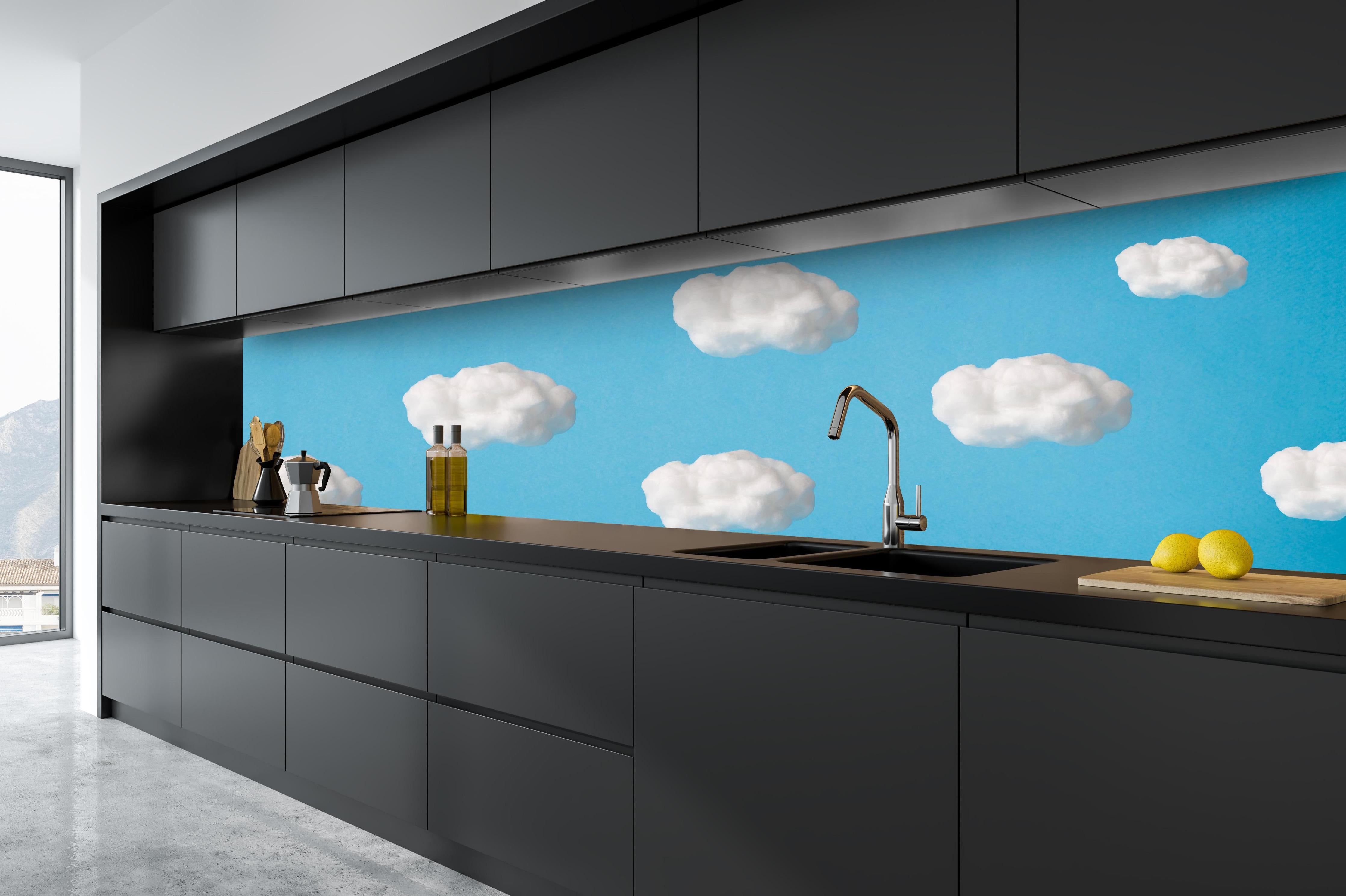 Küche - Wolke aus Watte auf himmelblauem Hintergrund hinter weißen Hochglanz-Küchenregalen und schwarzem Wasserhahn