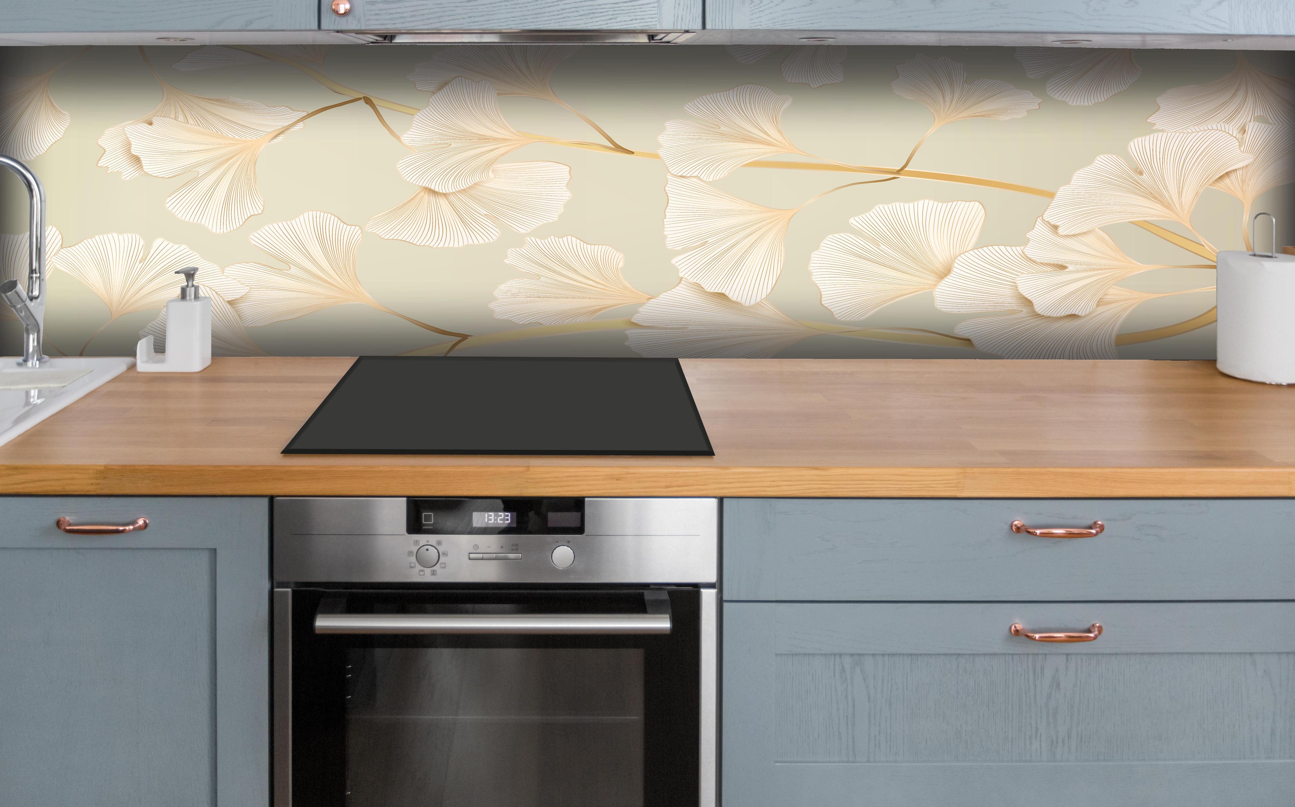 Küche - Zarte Ginkgo-Blatt-Muster in Pastellbeige hinter weißen Hochglanz-Küchenregalen und schwarzem Wasserhahn