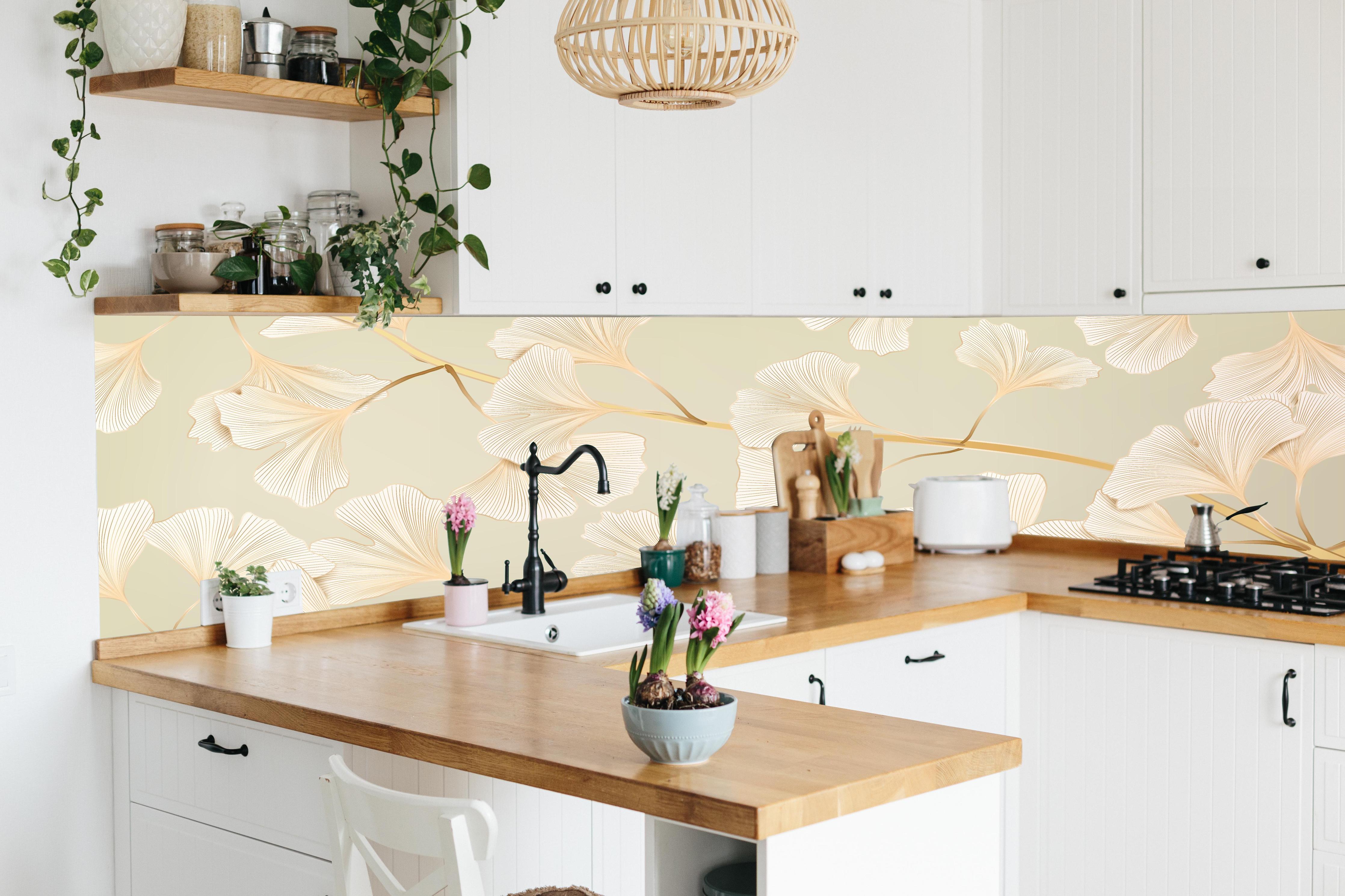 Küche - Zarte Ginkgo-Blatt-Muster in Pastellbeige hinter weißen Hochglanz-Küchenregalen und schwarzem Wasserhahn