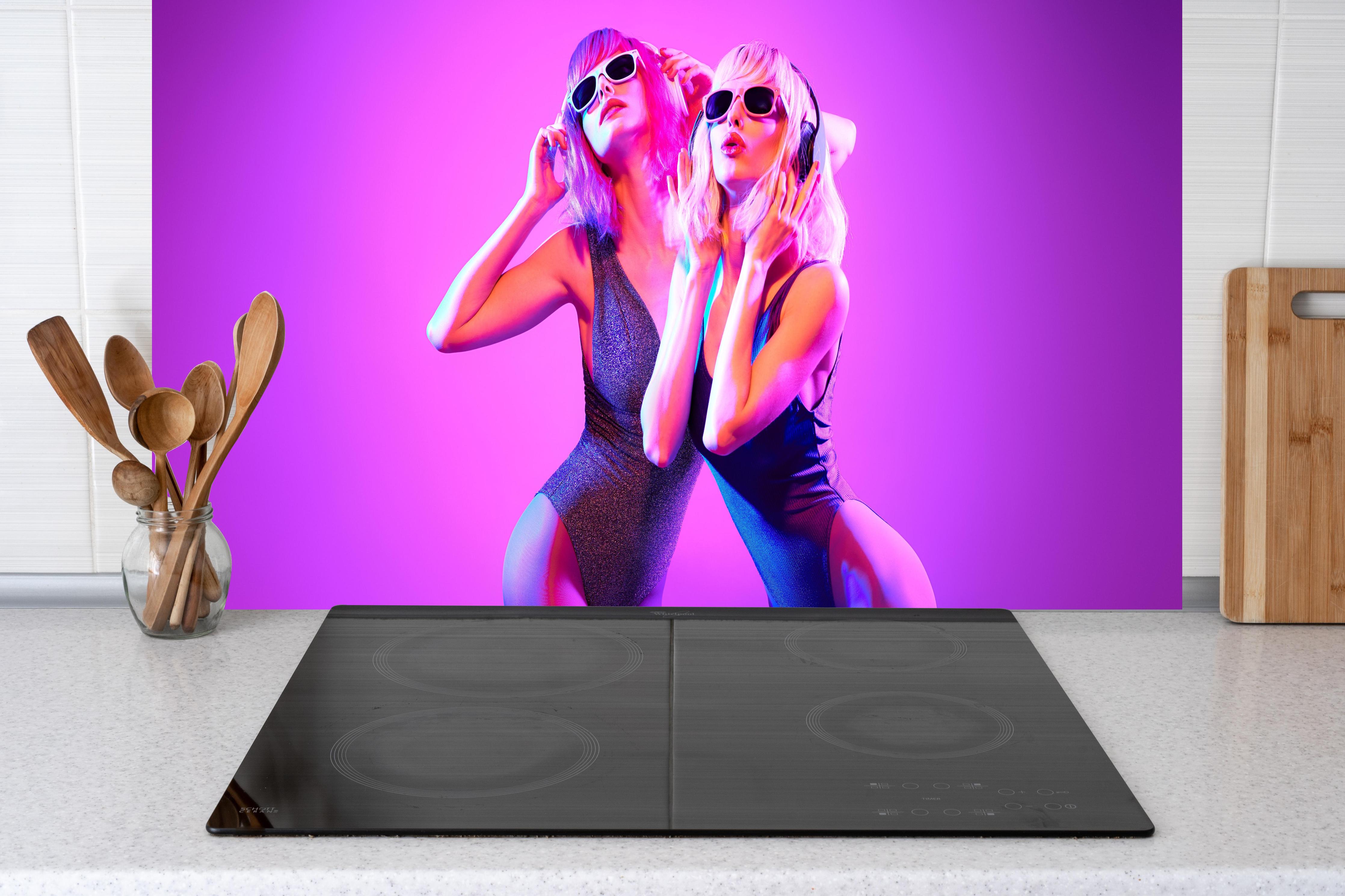 Küche - Zwei DJ Fitness Frau in bunten Neonlicht. Disco hinter weißen Hochglanz-Küchenregalen und schwarzem Wasserhahn