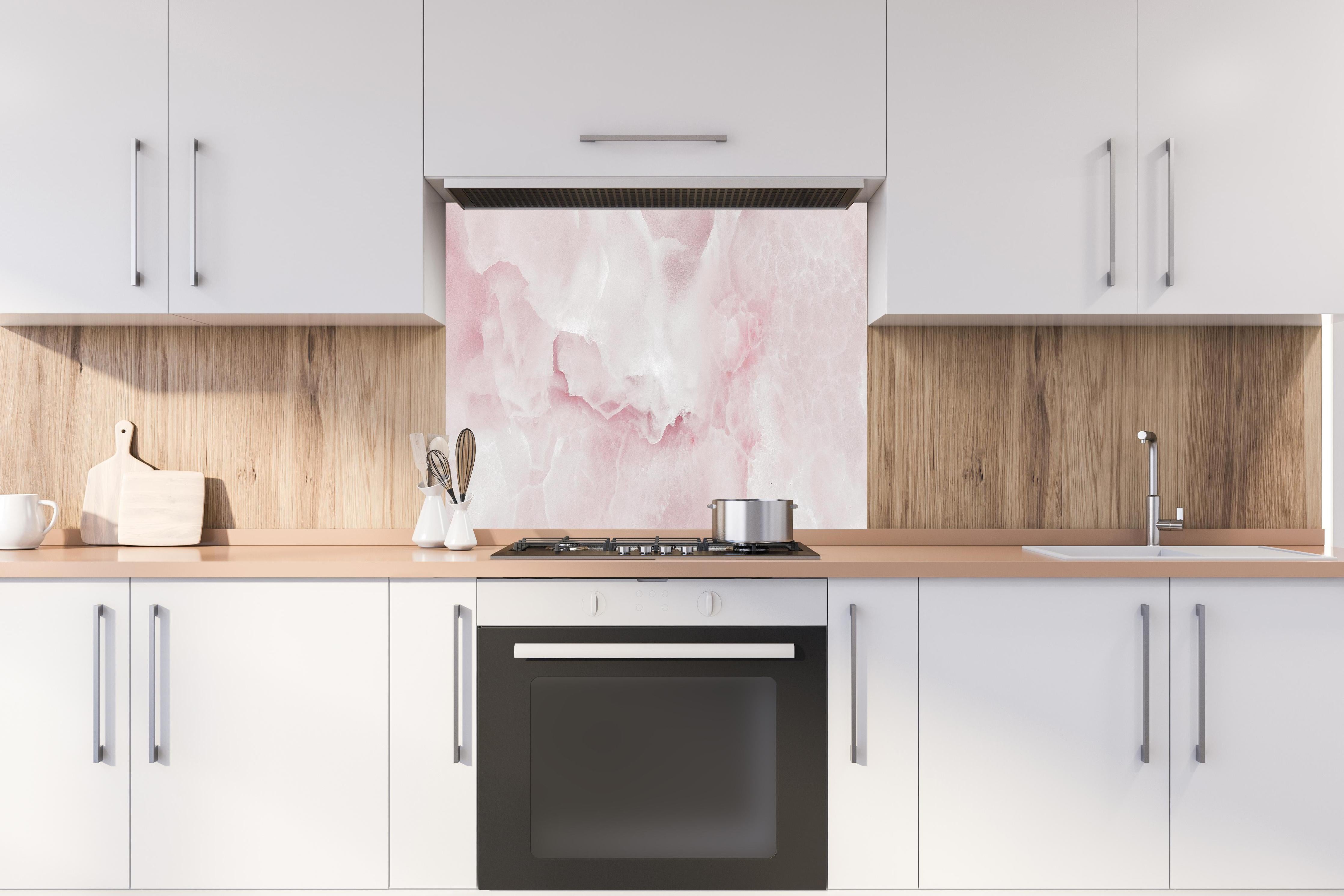 Spritzschutz -  Rosa Emperador Onyx Marmor hinter einem Cerankochfeld zwischen Holz-Kochutensilien
