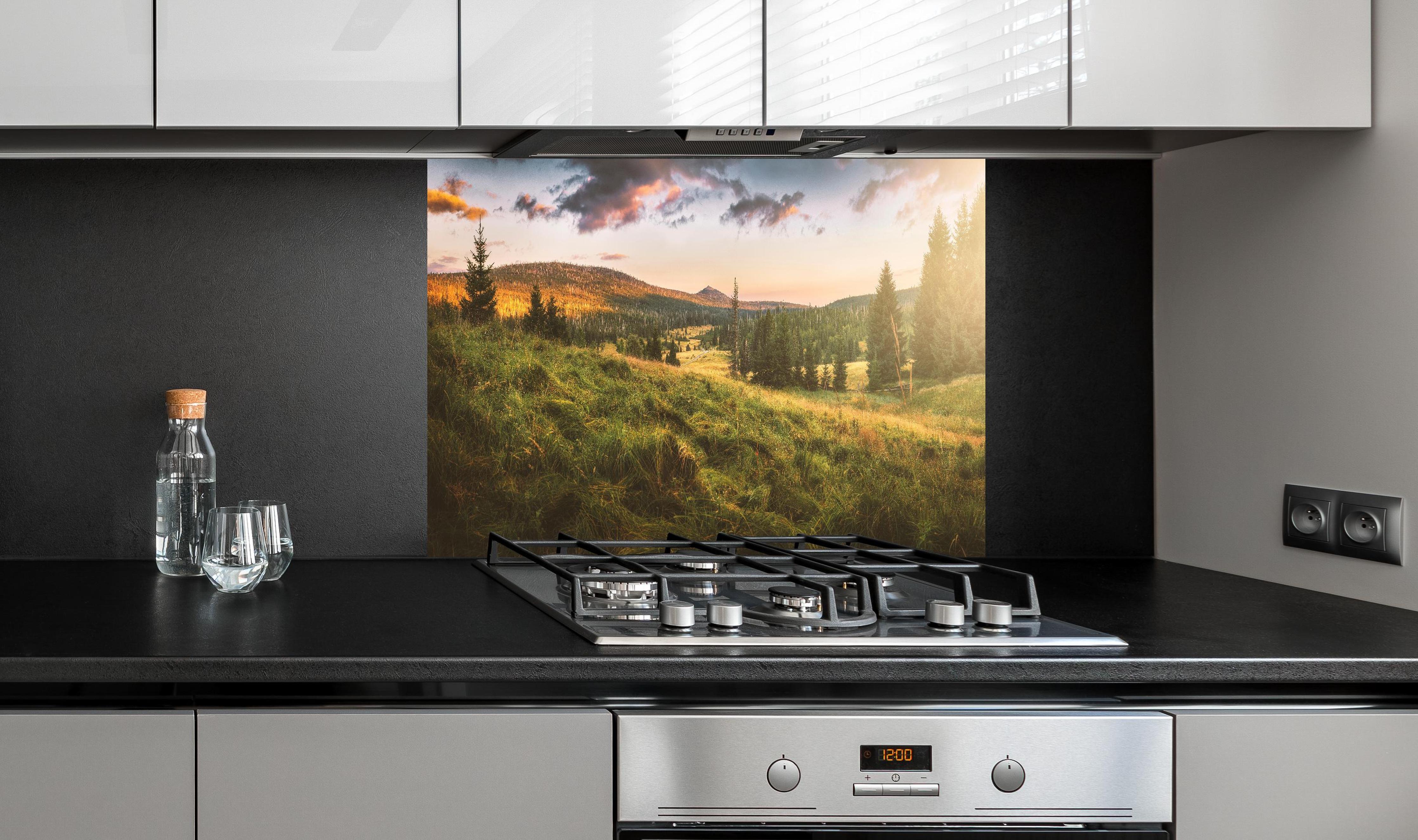 Spritzschutz - Abendlicher Berg Luzný - Tschechien hinter einem Cerankochfeld zwischen Holz-Kochutensilien
