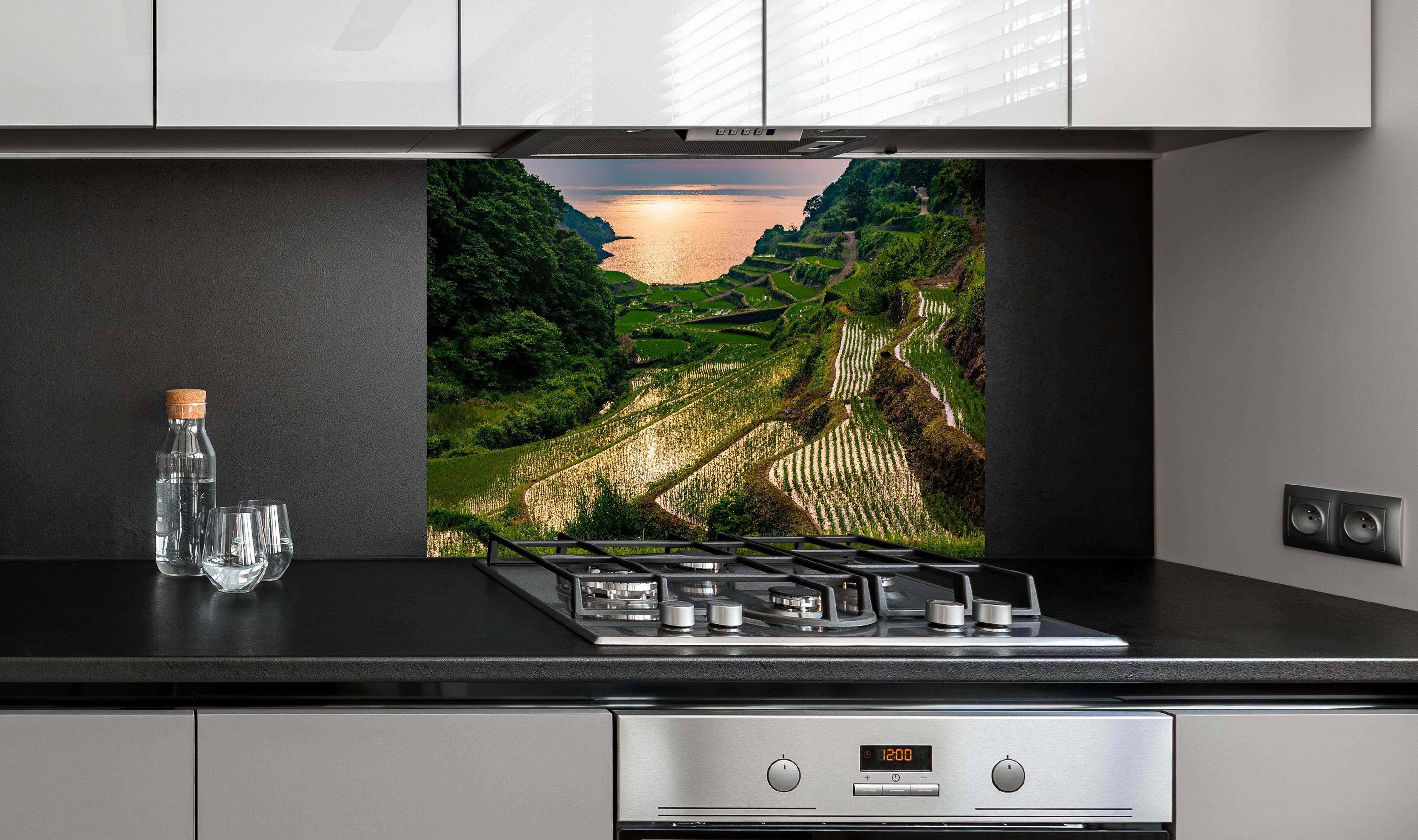 Spritzschutz - Abendlicher Blick japanische Berglandschaft hinter einem Cerankochfeld zwischen Holz-Kochutensilien
