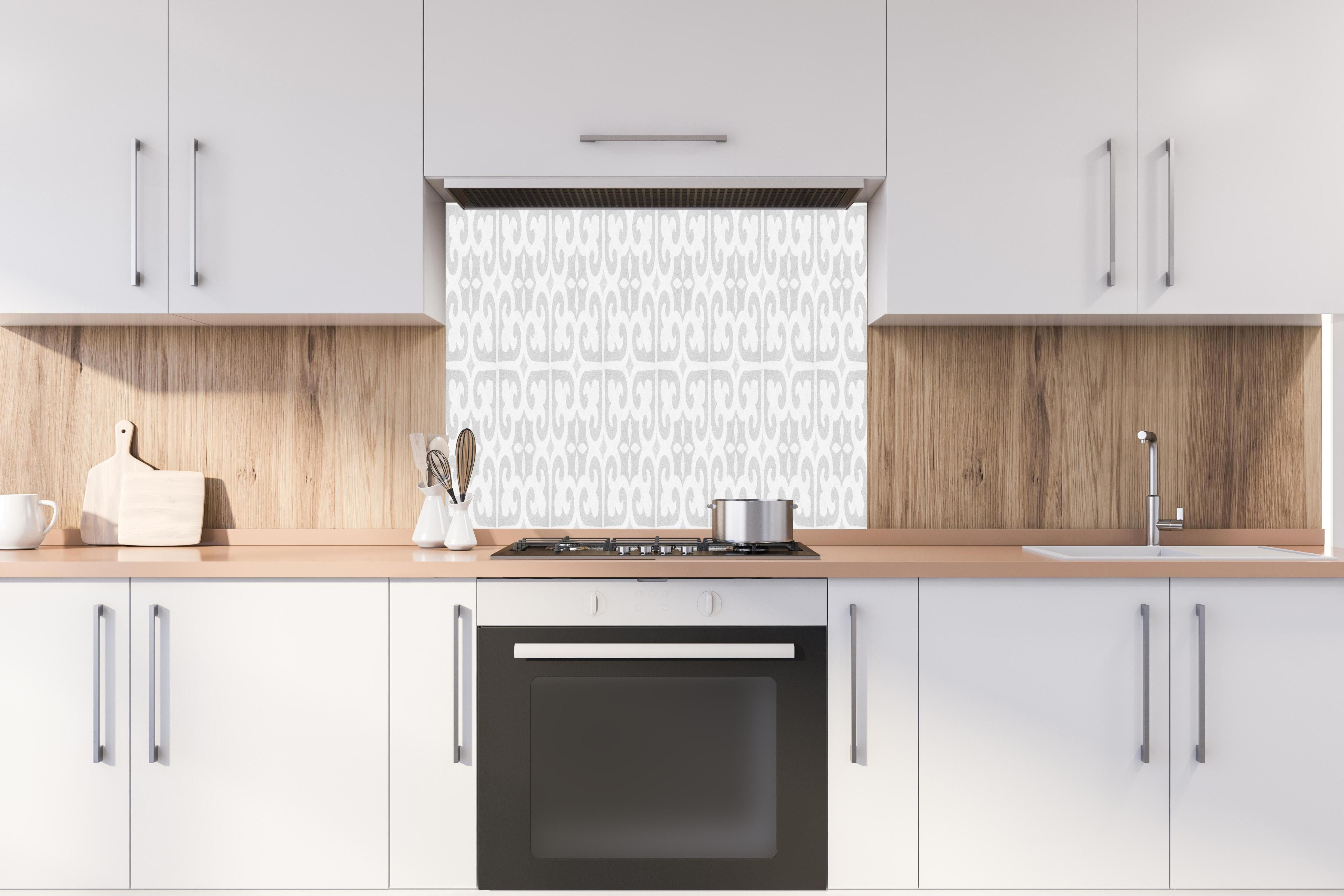 Spritzschutz - Abgenutztes Mosaik hinter einem Cerankochfeld zwischen Holz-Kochutensilien
