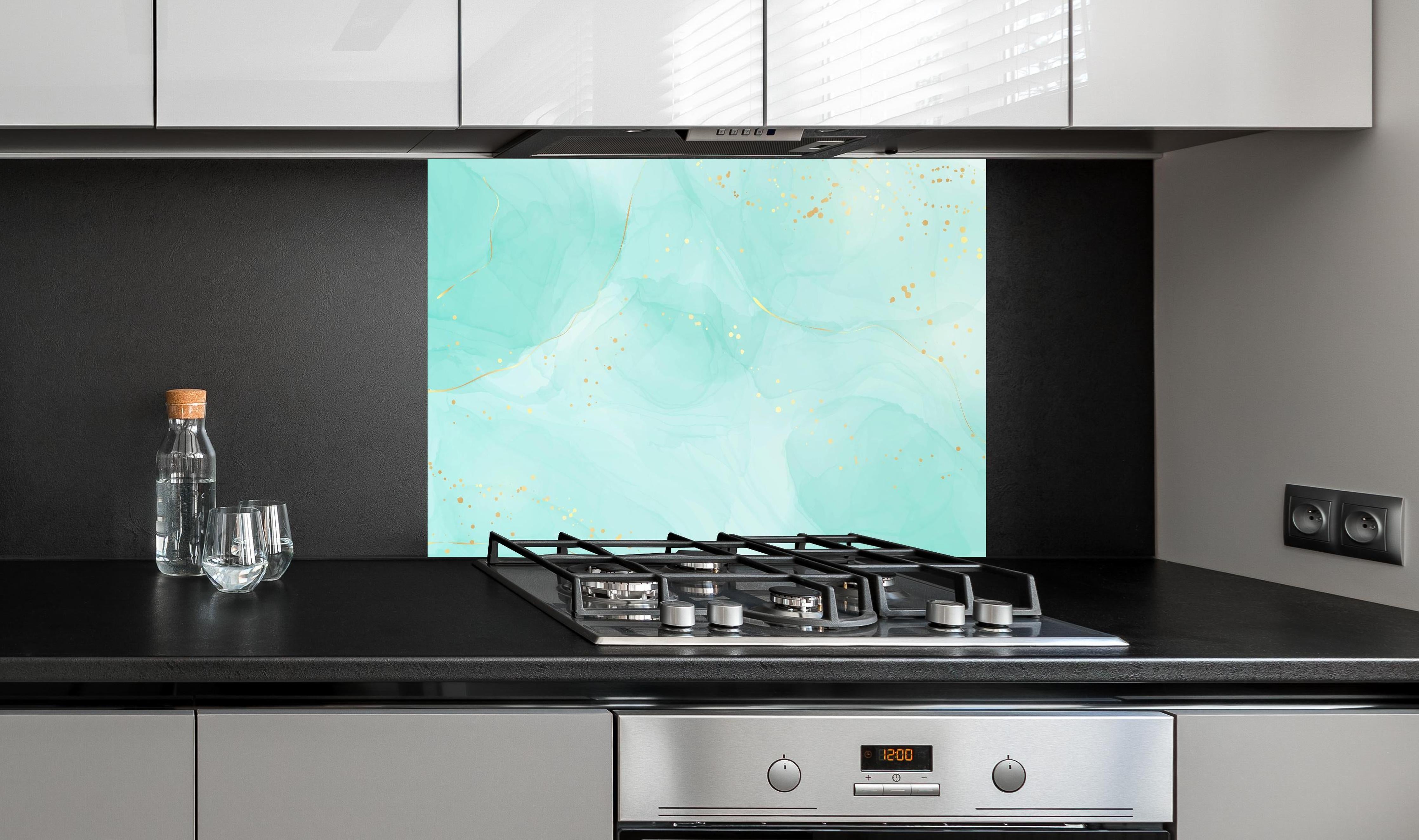 Spritzschutz - Abstrakte Aquarell-Kunst in Türkis mit Goldakzenten hinter einem Cerankochfeld zwischen Holz-Kochutensilien
