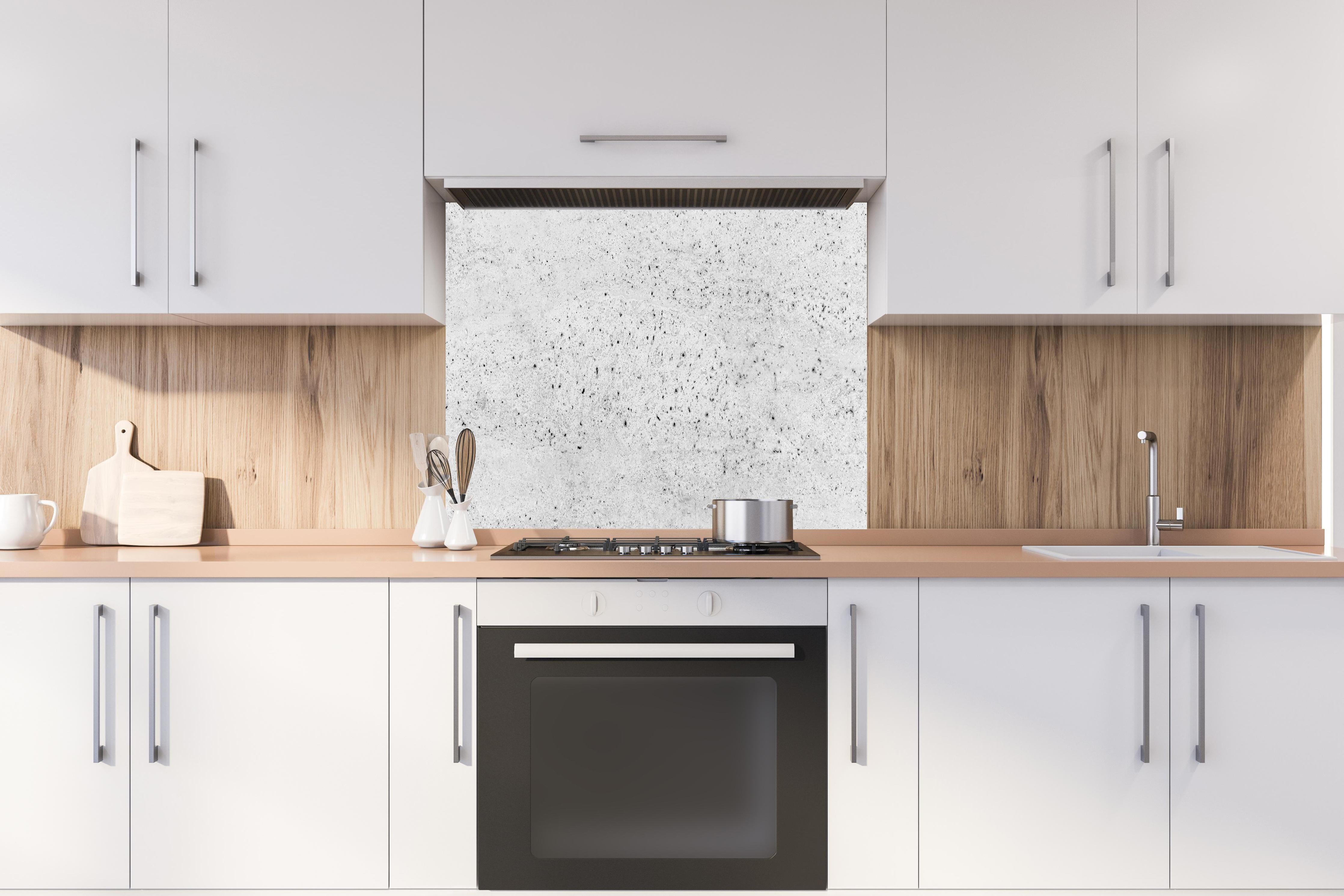 Spritzschutz - Abstrakte Betonstruktur hinter einem Cerankochfeld zwischen Holz-Kochutensilien
