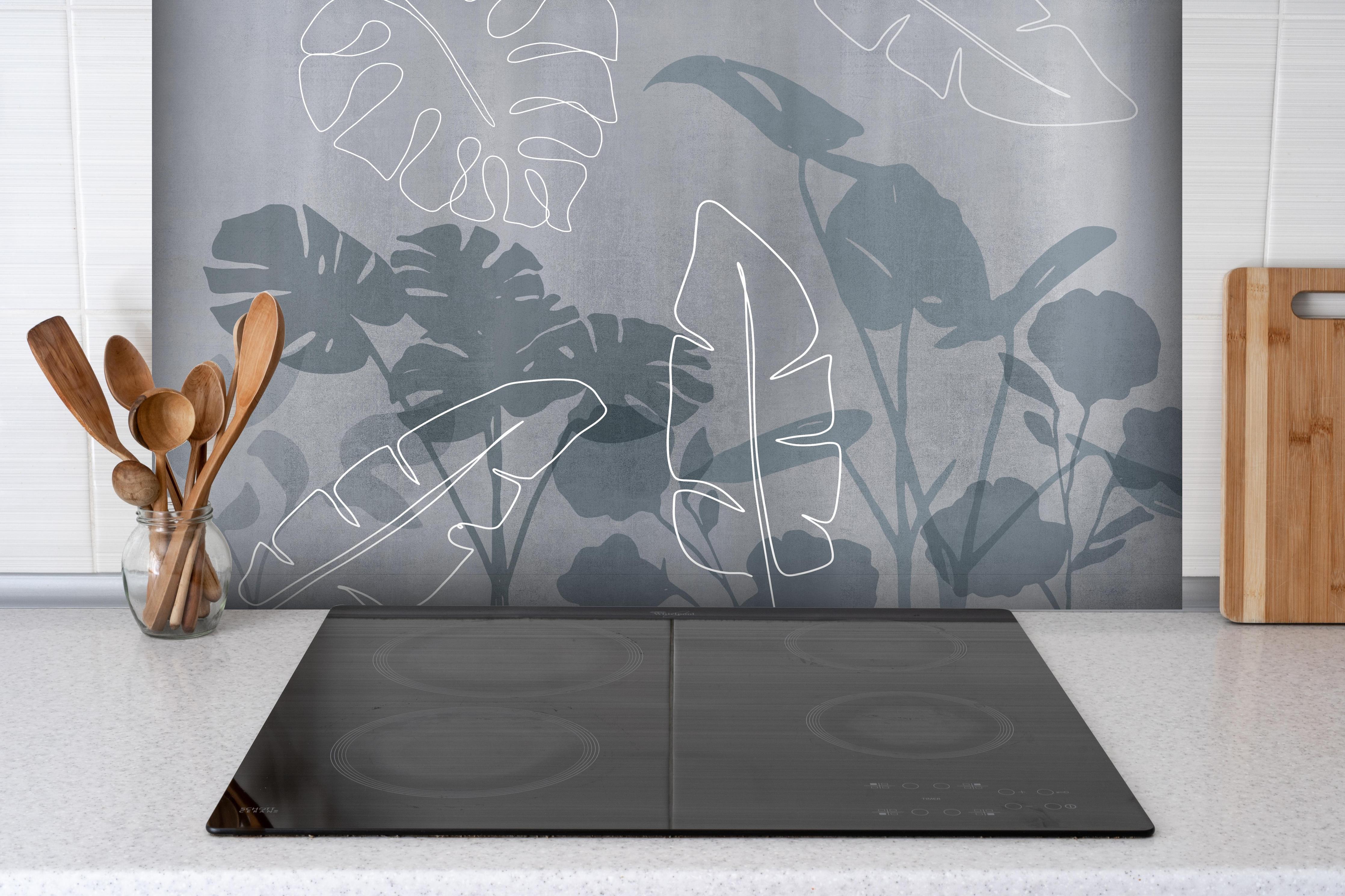 Spritzschutz - Abstrakte Blätter hinter einem Cerankochfeld zwischen Holz-Kochutensilien
