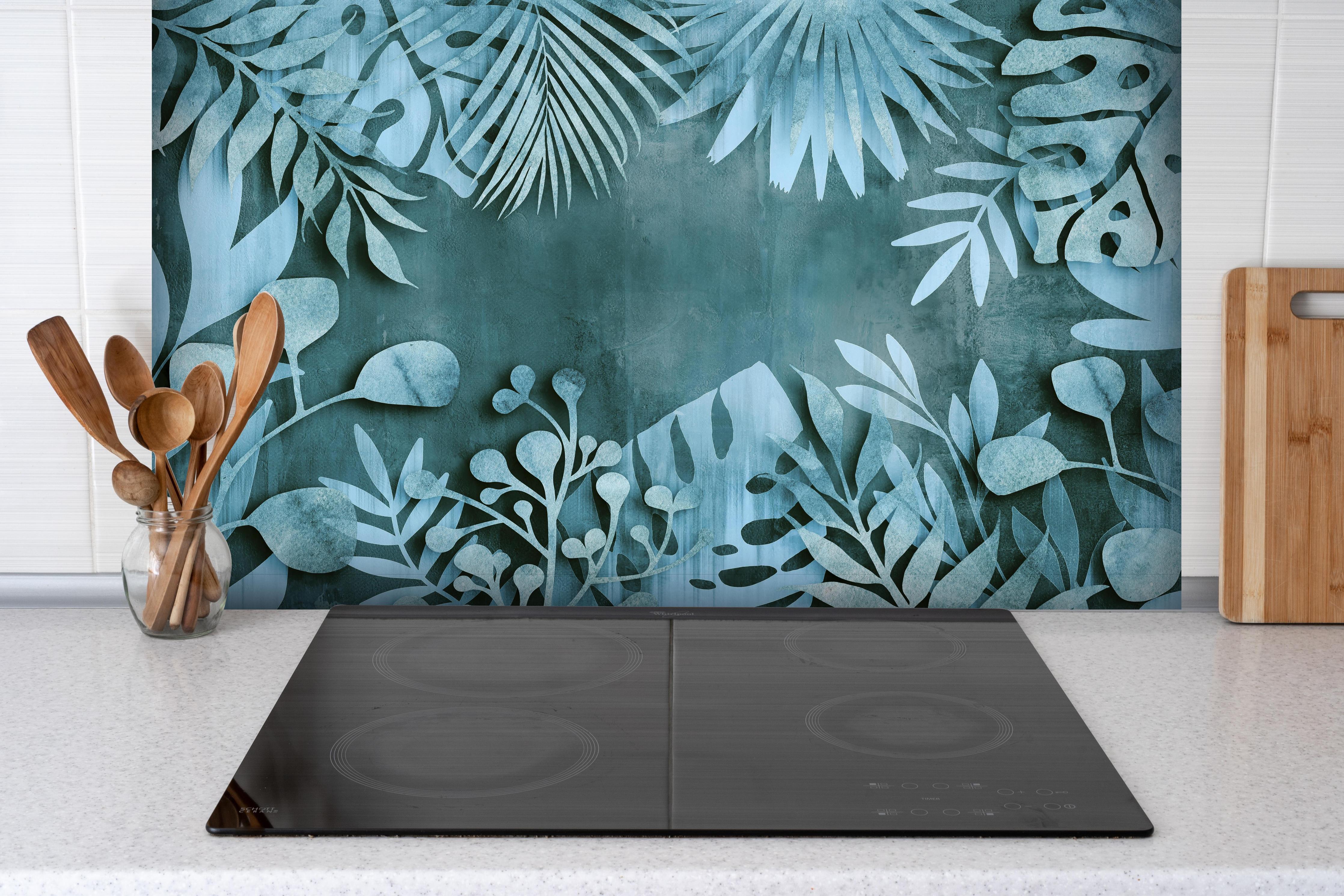 Spritzschutz - Abstrakte Blatt-Strukturen in Türkisblau hinter einem Cerankochfeld zwischen Holz-Kochutensilien
