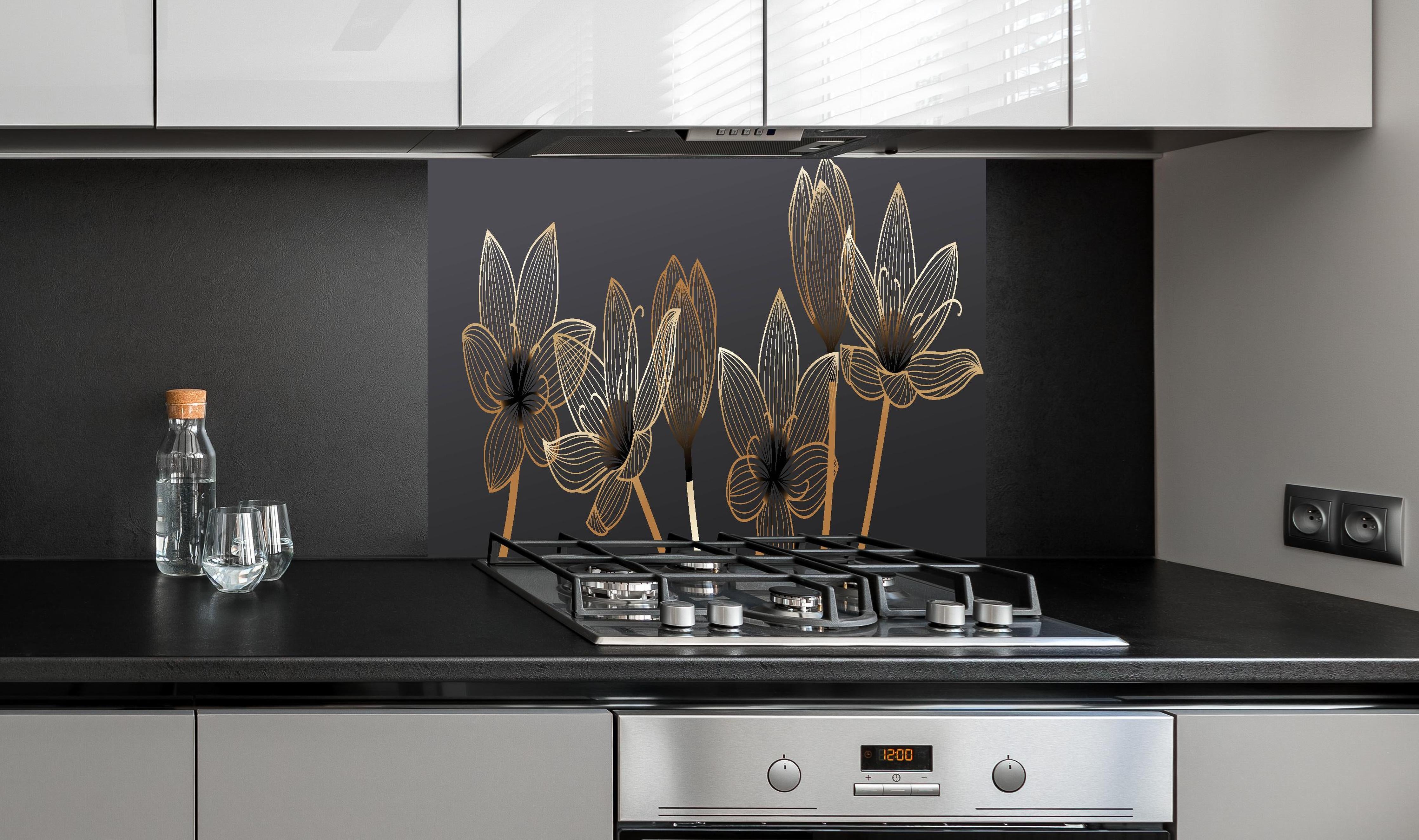 Spritzschutz - Abstrakte Blumen Gold Schwarz Design hinter einem Cerankochfeld zwischen Holz-Kochutensilien
