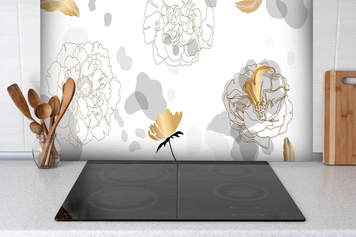 Spritzschutz - Abstrakte Blumen Kunst in Gold und Grau hinter einem Cerankochfeld zwischen Holz-Kochutensilien
