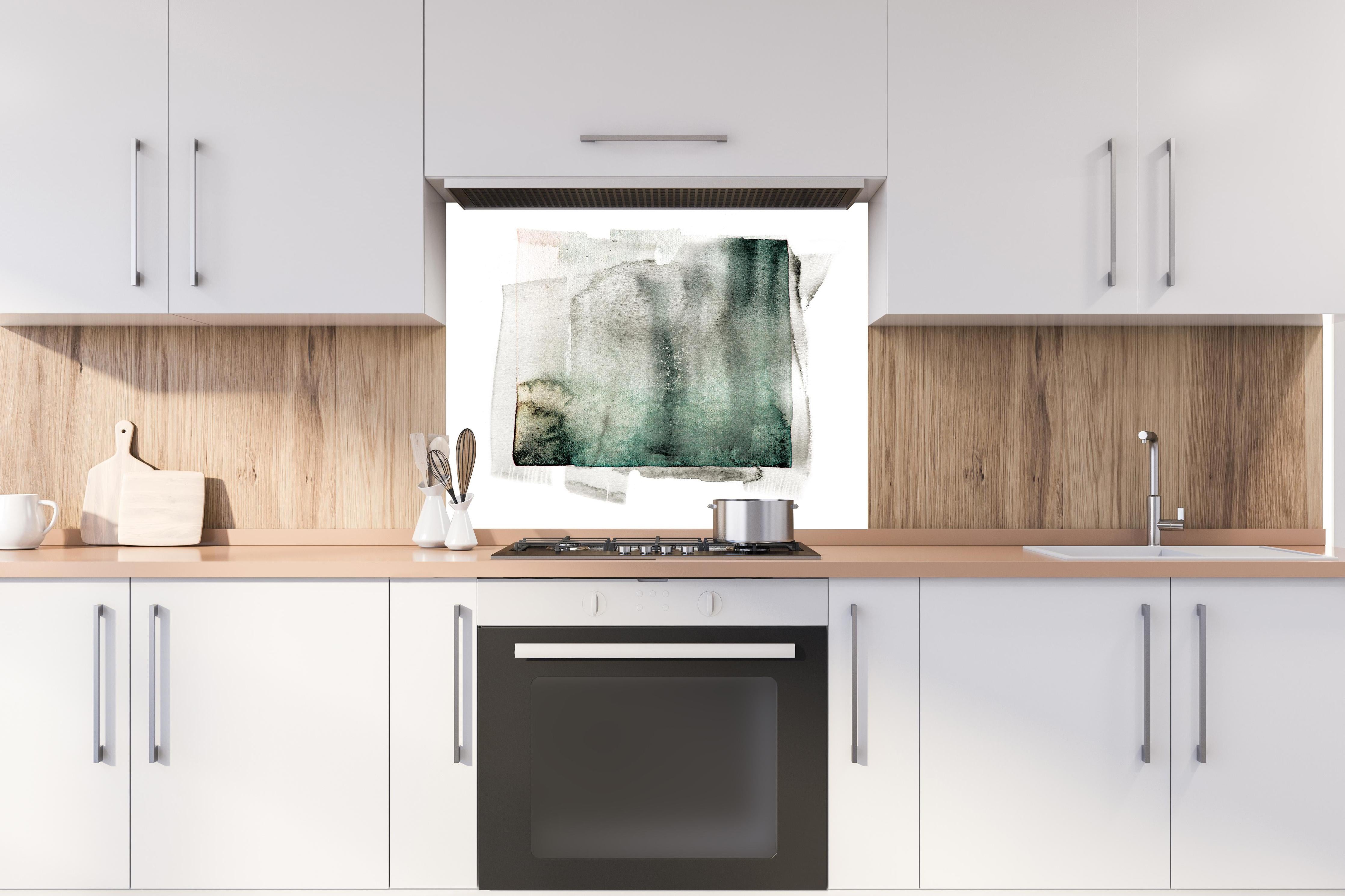 Spritzschutz - Abstrakte Kunst in Grün auf hellem Hintergrund hinter einem Cerankochfeld zwischen Holz-Kochutensilien

