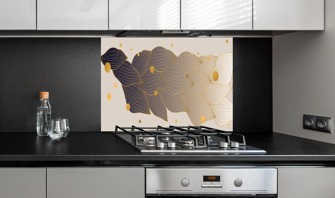 Spritzschutz - Abstrakte Kunst mit goldenen Akzenten hinter einem Cerankochfeld zwischen Holz-Kochutensilien

