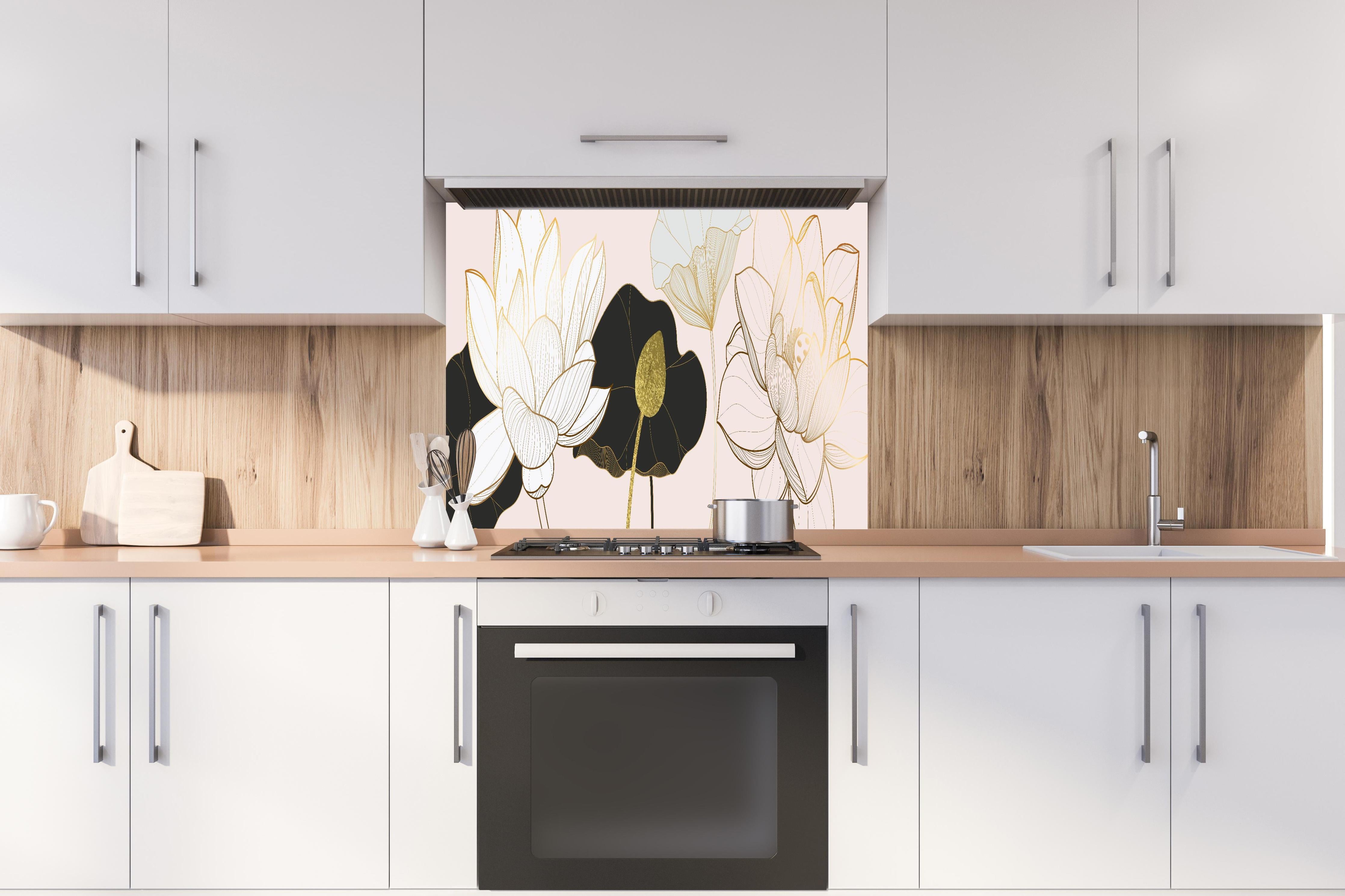 Spritzschutz - Abstrakte Lotusblüten in Gold-Schwarz-Design hinter einem Cerankochfeld zwischen Holz-Kochutensilien
