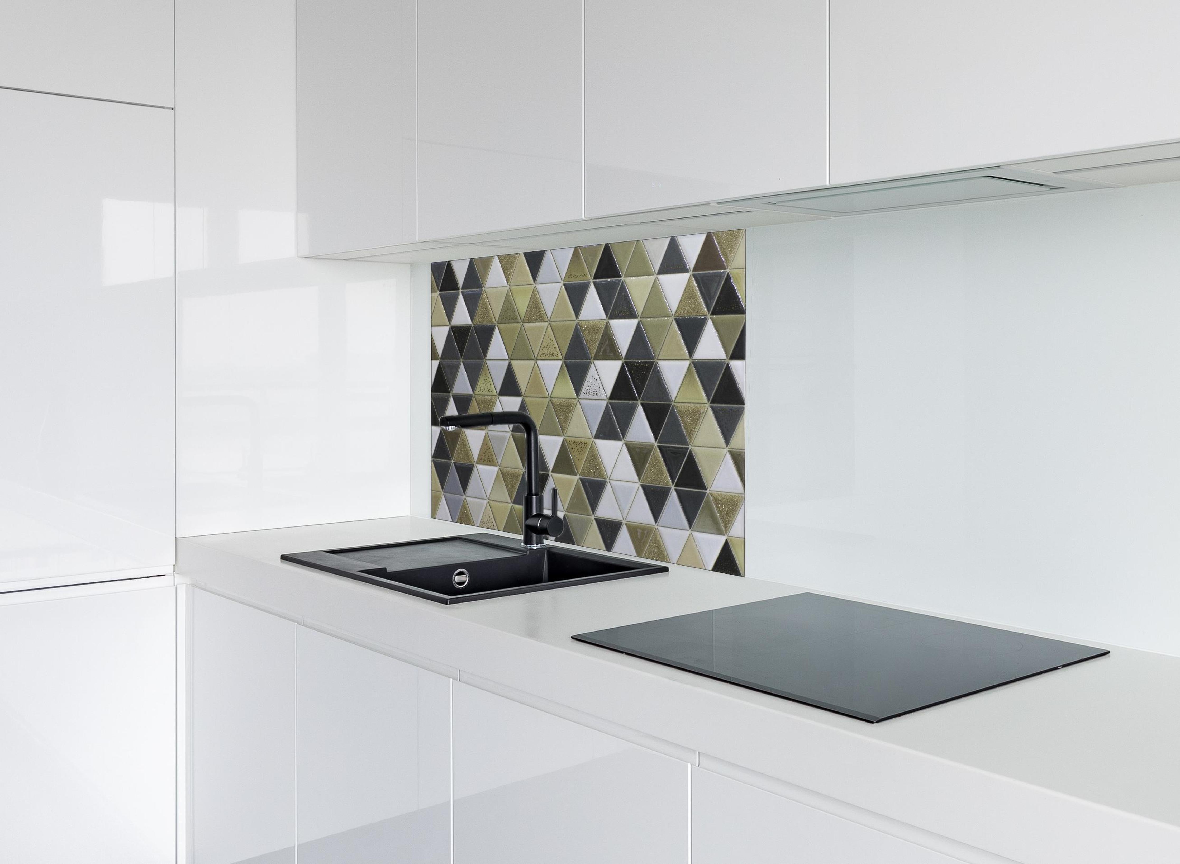 Spritzschutz - Abstrakte Mosaikfliese in Grautönen hinter einem Cerankochfeld zwischen Holz-Kochutensilien
