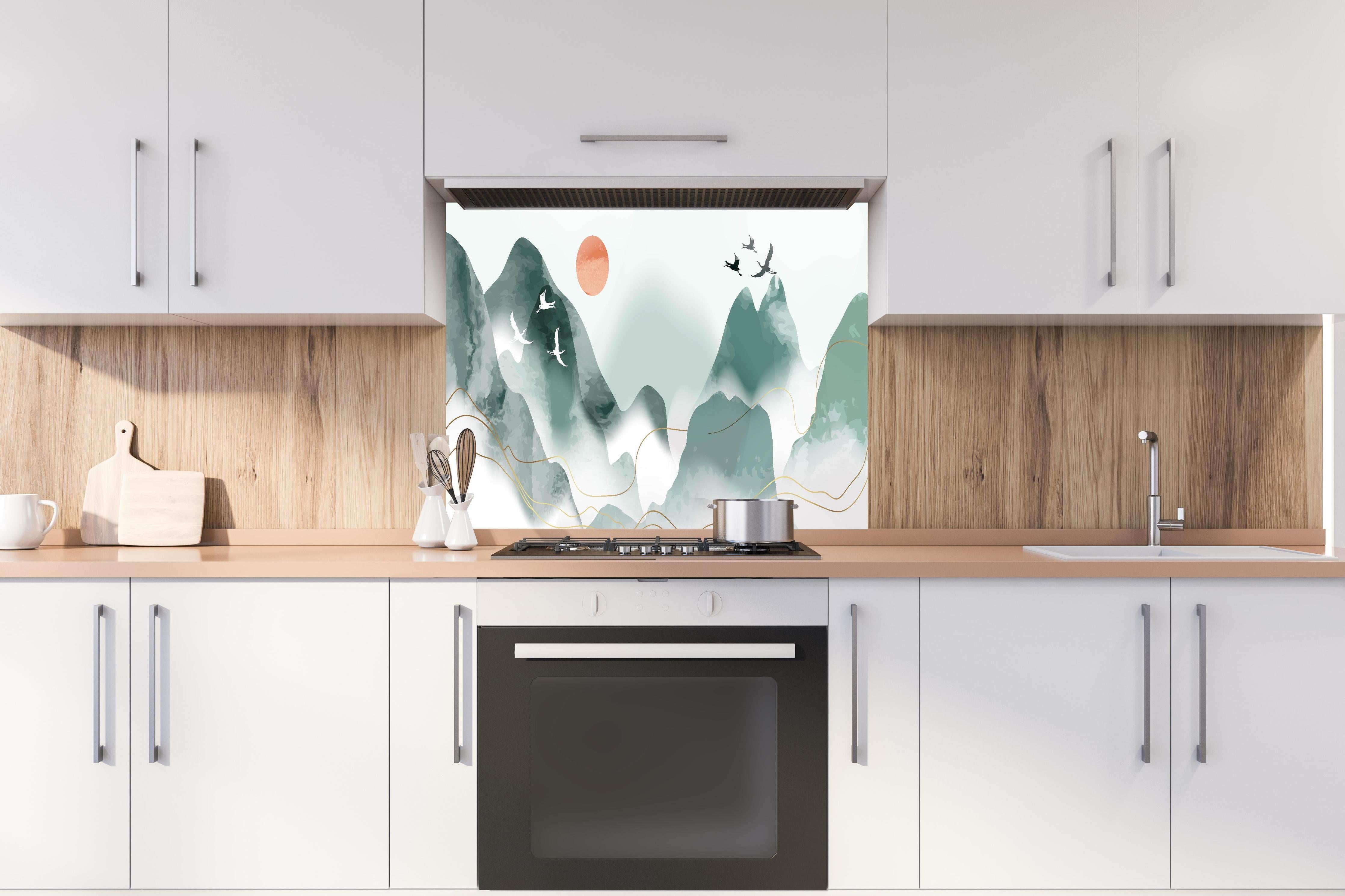 Spritzschutz - Abstrakte Pastell Berglandschaft mit Sonne hinter einem Cerankochfeld zwischen Holz-Kochutensilien
