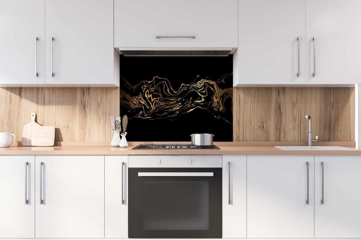 Spritzschutz - Abstrakte goldene Marmortextur mit Wellenlinien hinter einem Cerankochfeld zwischen Holz-Kochutensilien
