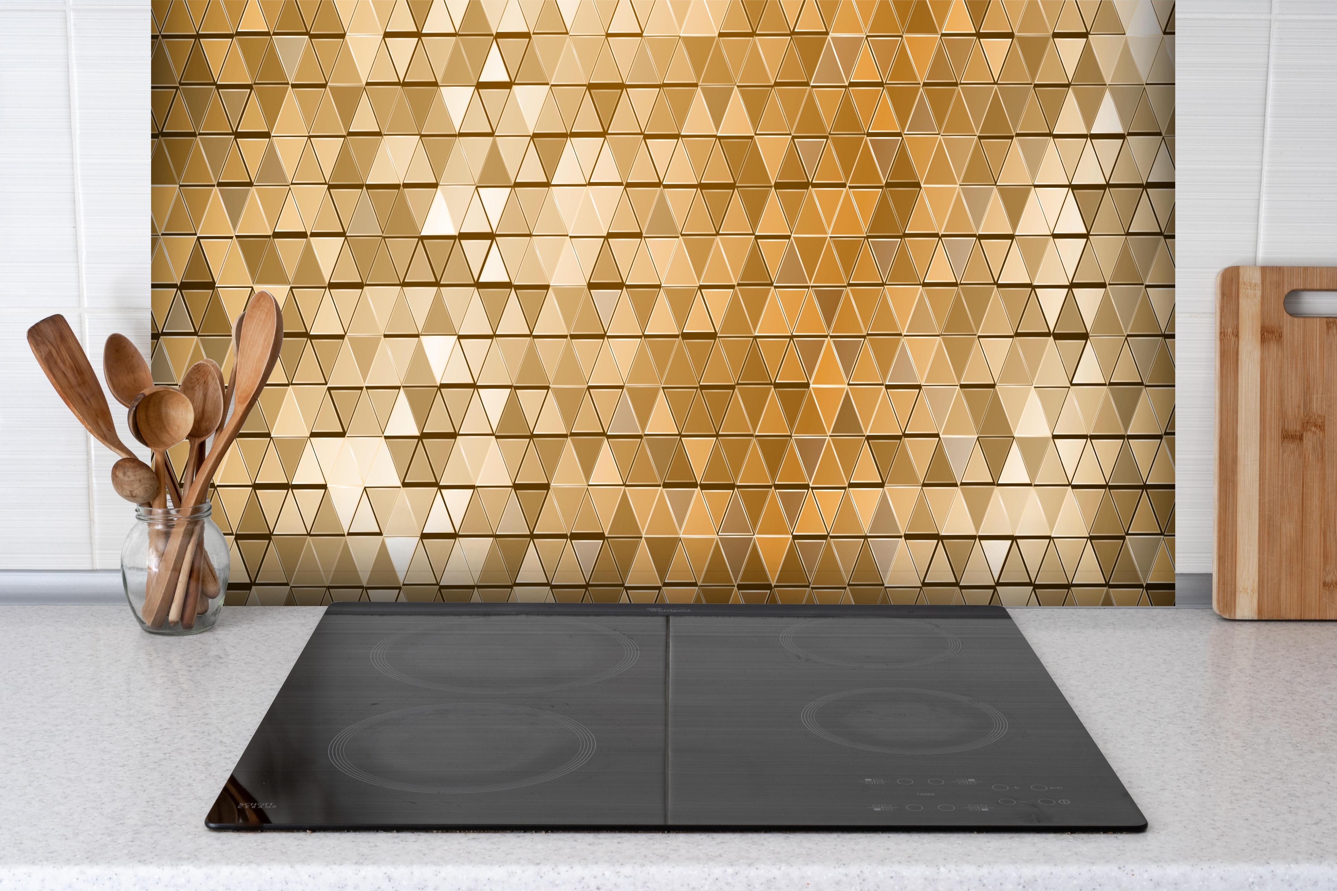 Spritzschutz - Abstrakte goldene Mosaik Wandverkleidung hinter einem Cerankochfeld zwischen Holz-Kochutensilien
