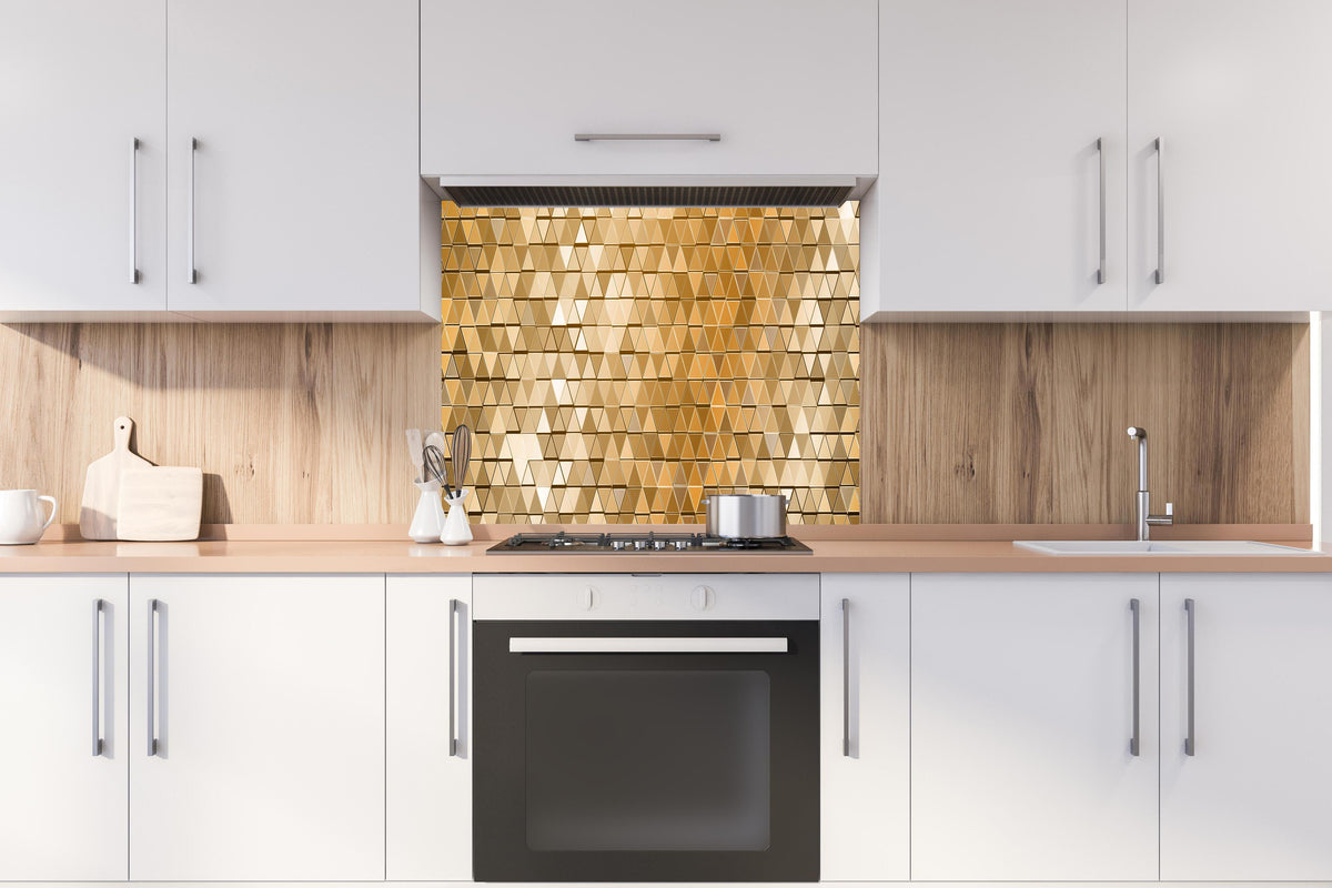 Spritzschutz - Abstrakte goldene Mosaik Wandverkleidung hinter einem Cerankochfeld zwischen Holz-Kochutensilien
