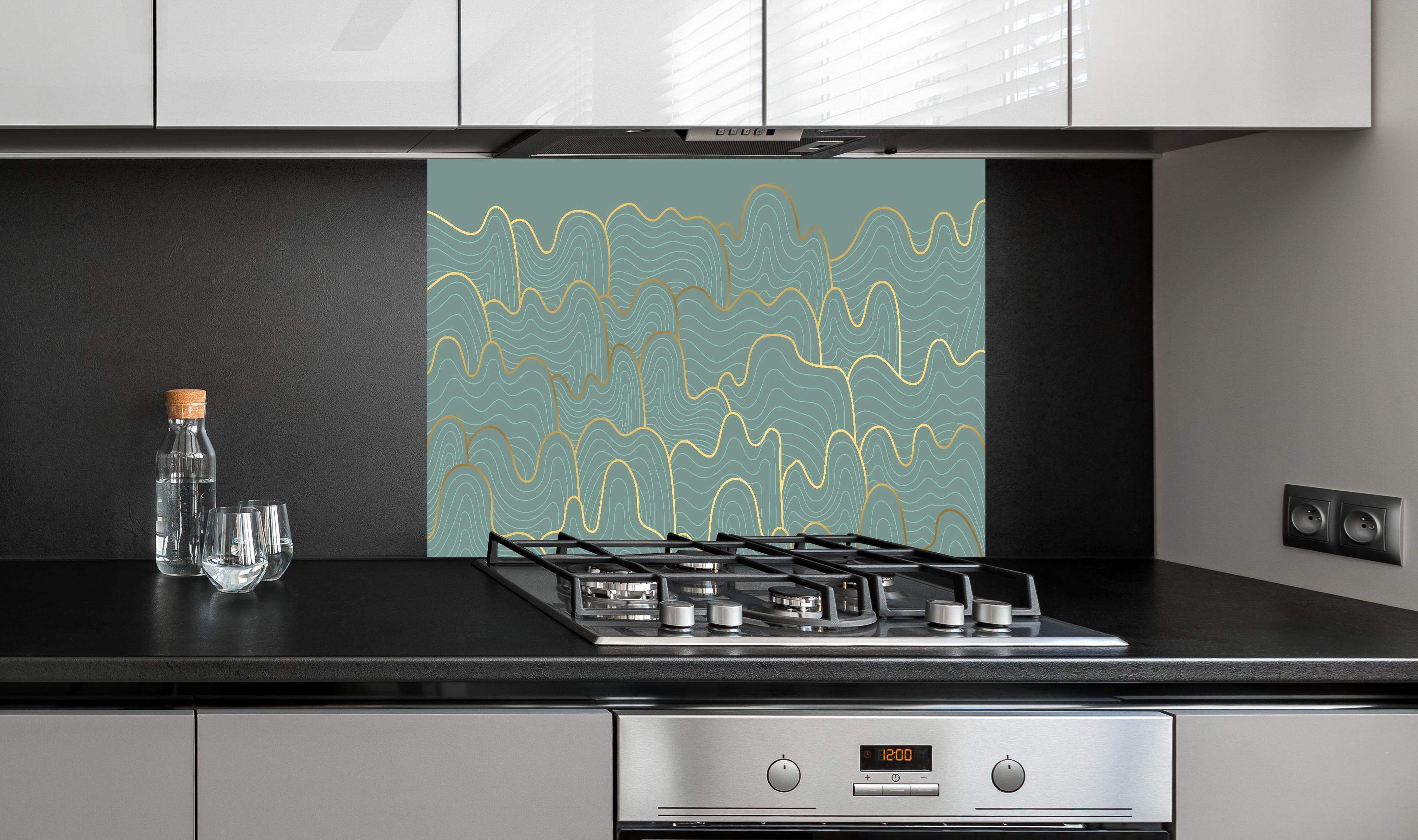 Spritzschutz - Abstrakte graue Wellentextur und Goldlinien hinter einem Cerankochfeld zwischen Holz-Kochutensilien
