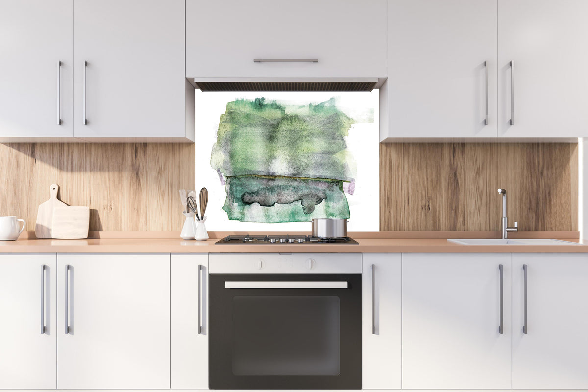 Spritzschutz - Abstrakte grün-weiße Aquarelltextur auf Papier hinter einem Cerankochfeld zwischen Holz-Kochutensilien
