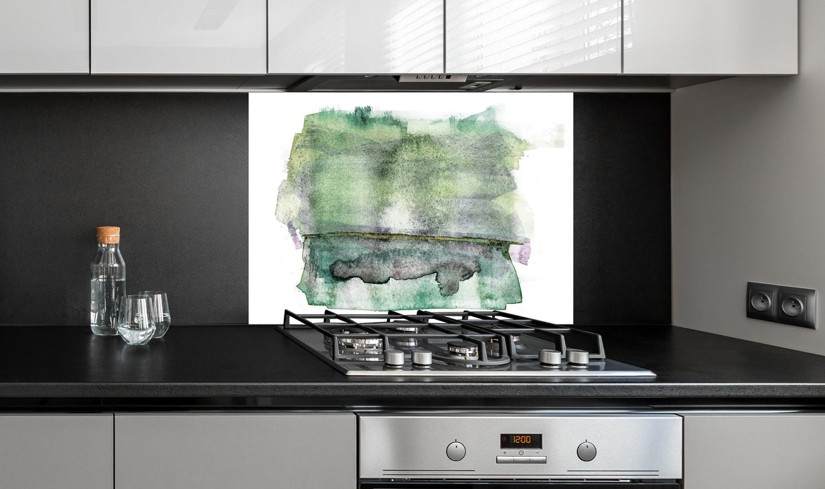 Spritzschutz - Abstrakte grün-weiße Aquarelltextur auf Papier hinter einem Cerankochfeld zwischen Holz-Kochutensilien
